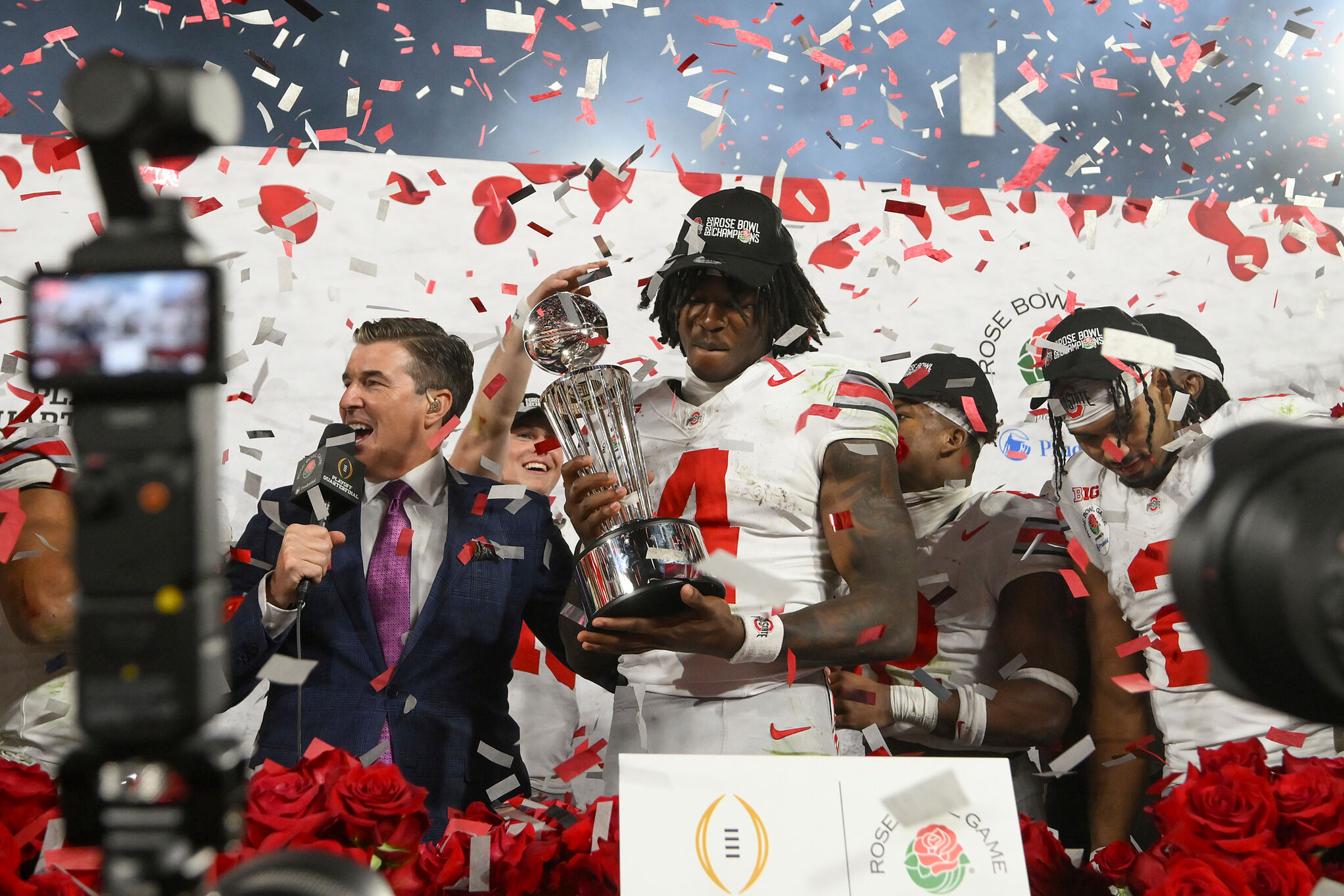 Ohio State wide receiver Jeremiah Smith (4) holds the trophy as he celebrates with teammates after the Rose Bowl