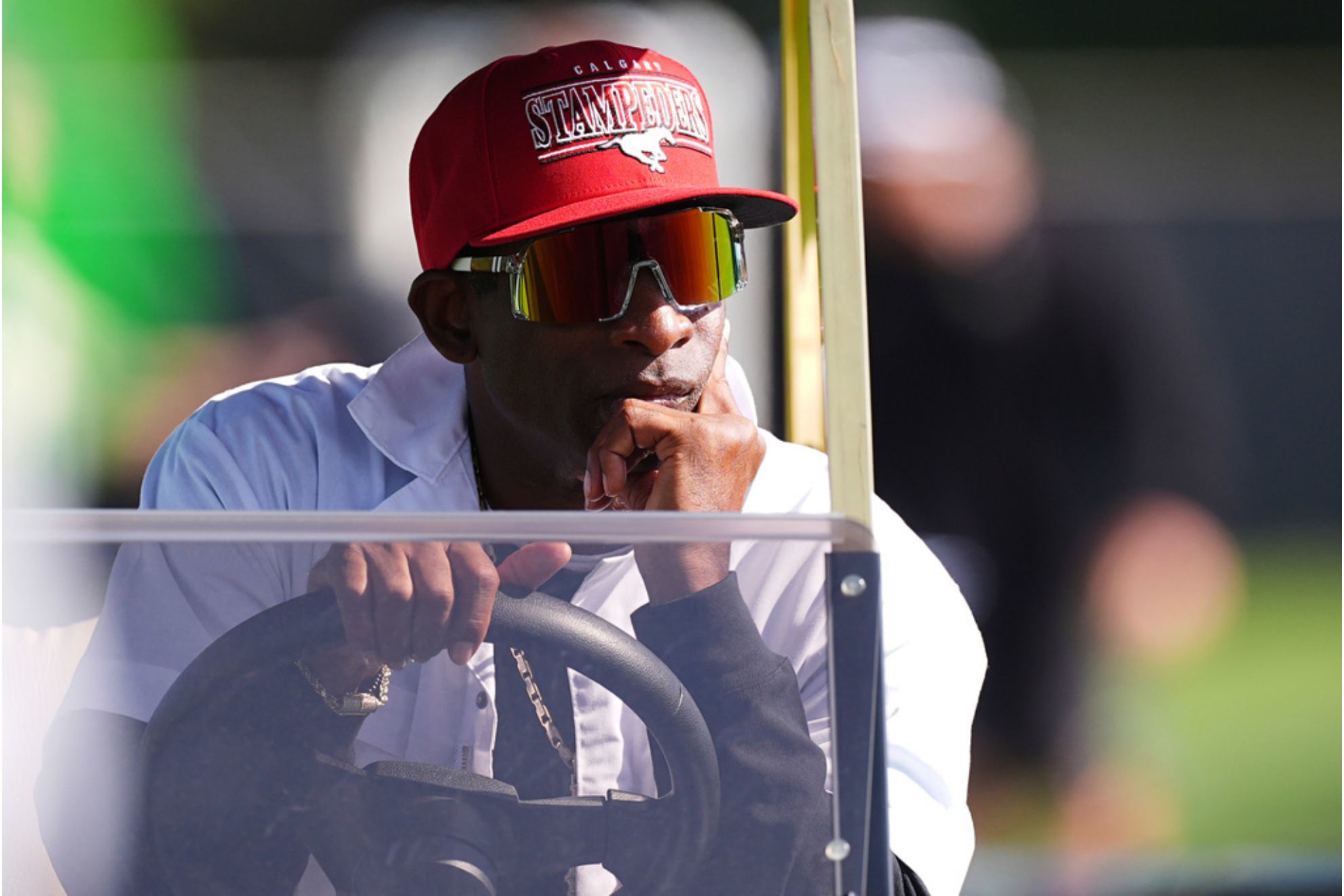 Colorado head coach Deion Sanders looks on from a golf cart as players take part in drills during NCAA college football practice