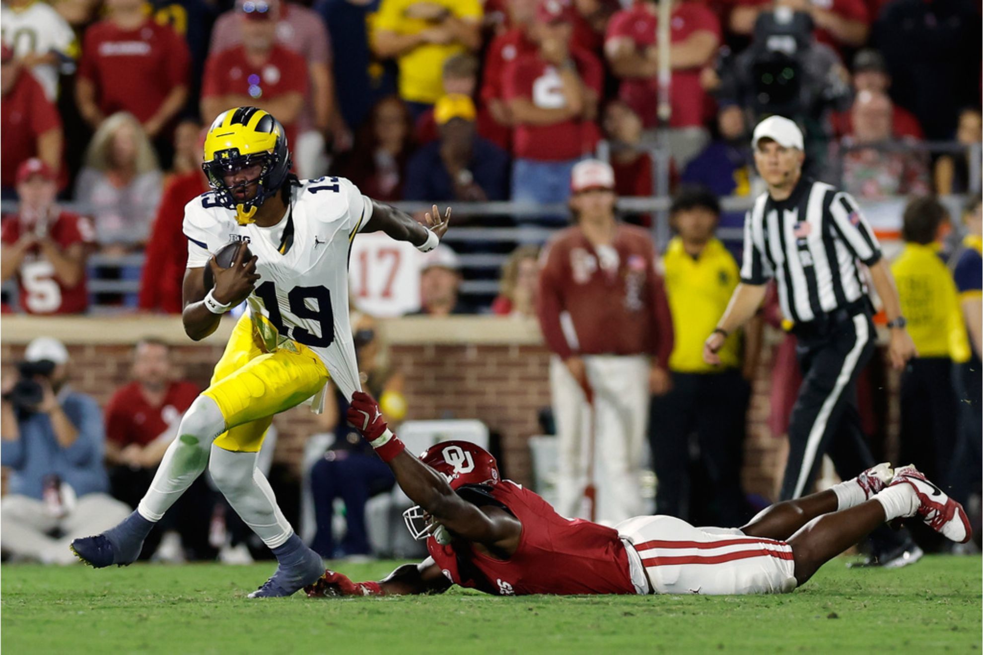 Oklahoma linebacker Sammy Omosigho pulls on Michigan quarterback Bryce Underwood jersey during the second half of an NCAA college football game