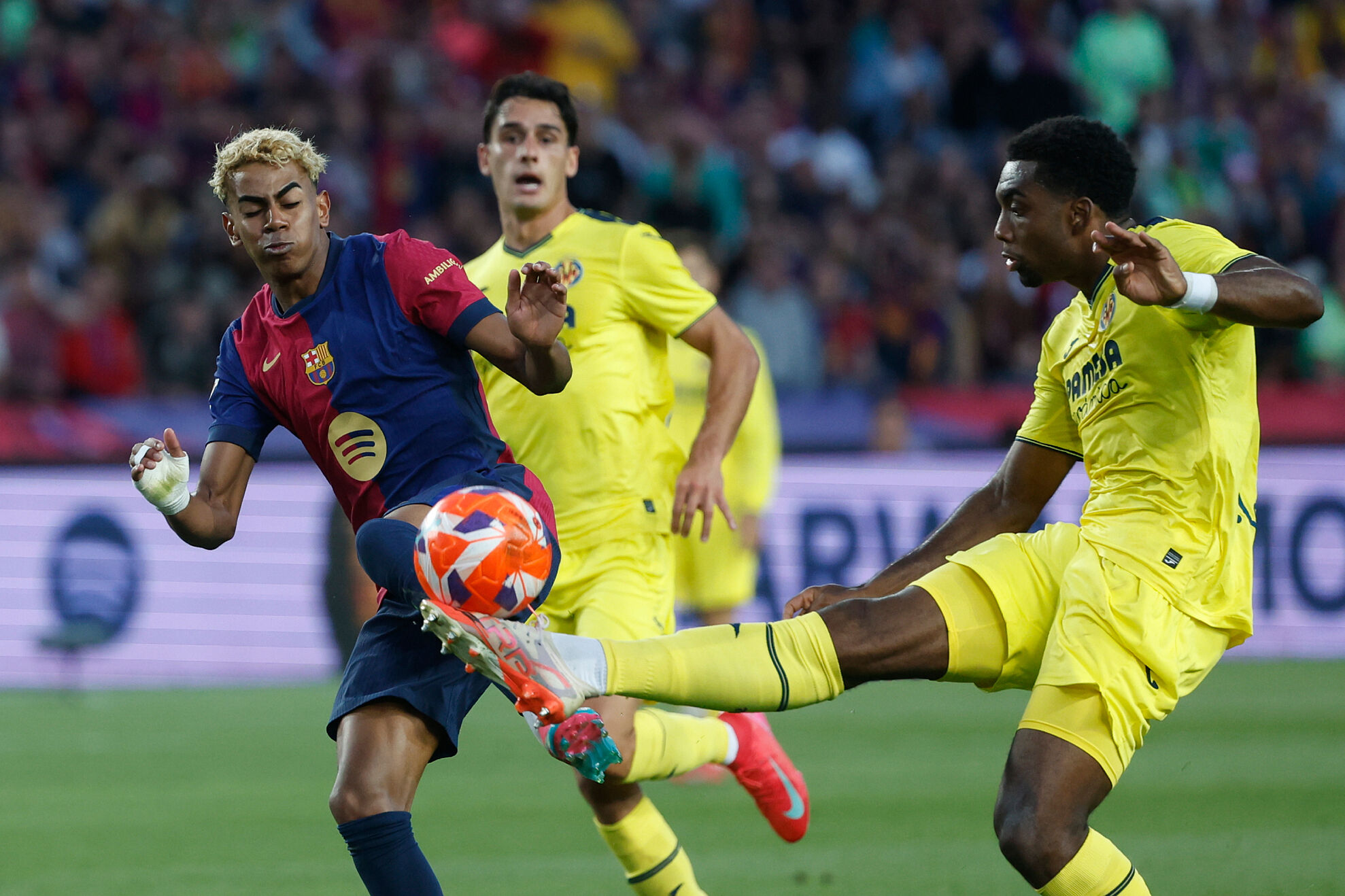 Barcelona's Lamine Yamal, left, and Villarreal's Logan Costa challenge for the ball during the Spanish La Liga soccer match between Barcelona and Villarreal at Lluis Companys Olympic Stadium in Barcelona, Spain, Sunday, May 18, 2025.