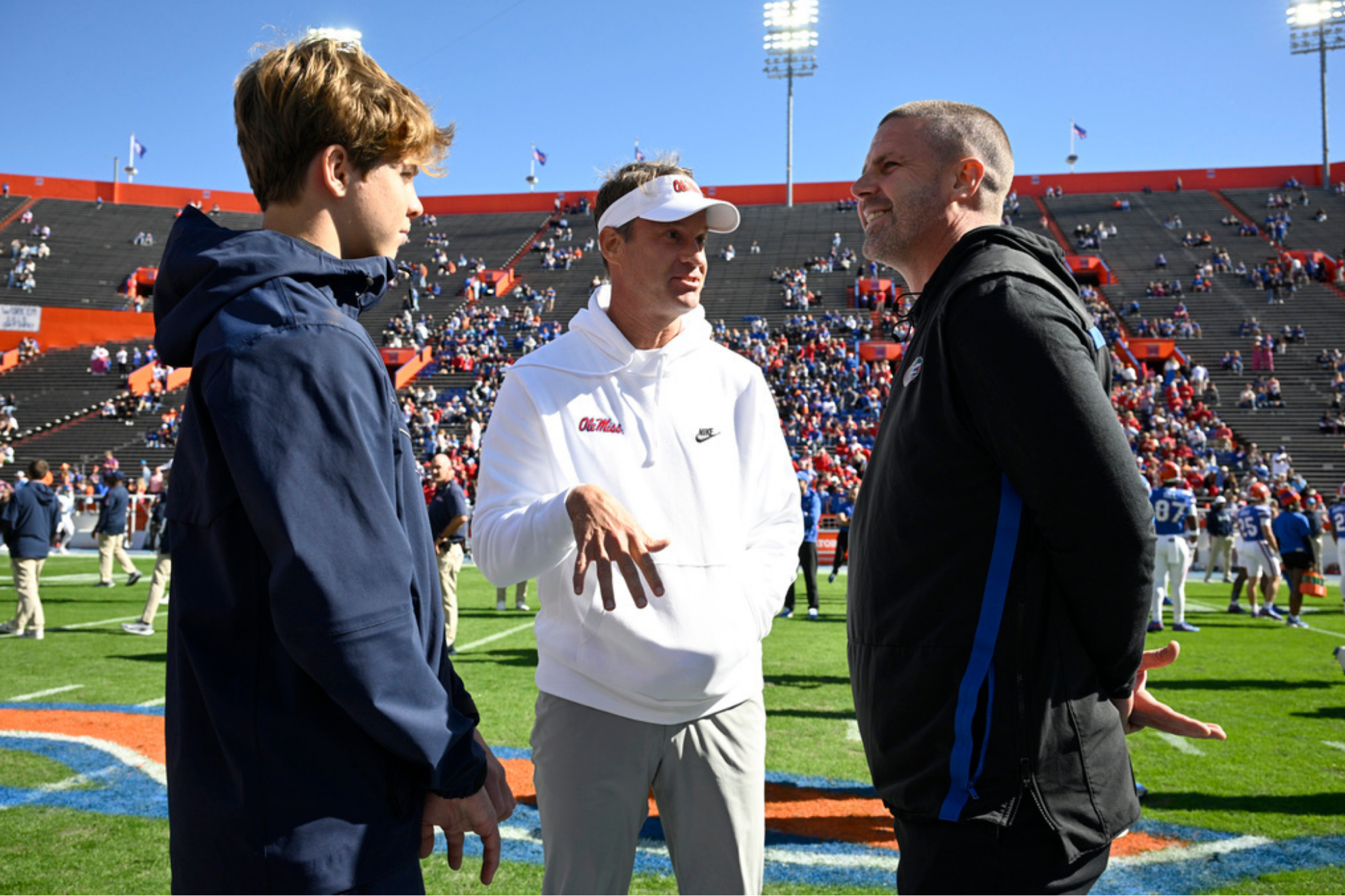 Mississippi head coach Lane Kiffin, center, and his son Knox Kiffin, left, chat with Florida head coach Billy Napier