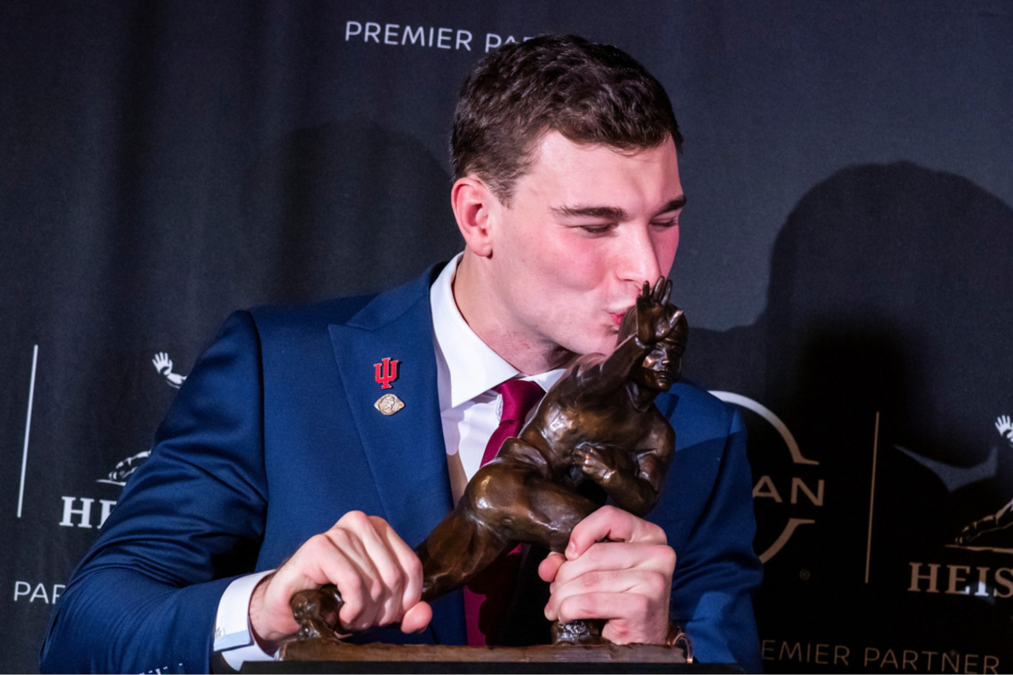 Indiana quarterback Fernando Mendoza kisses the Heisman Trophy