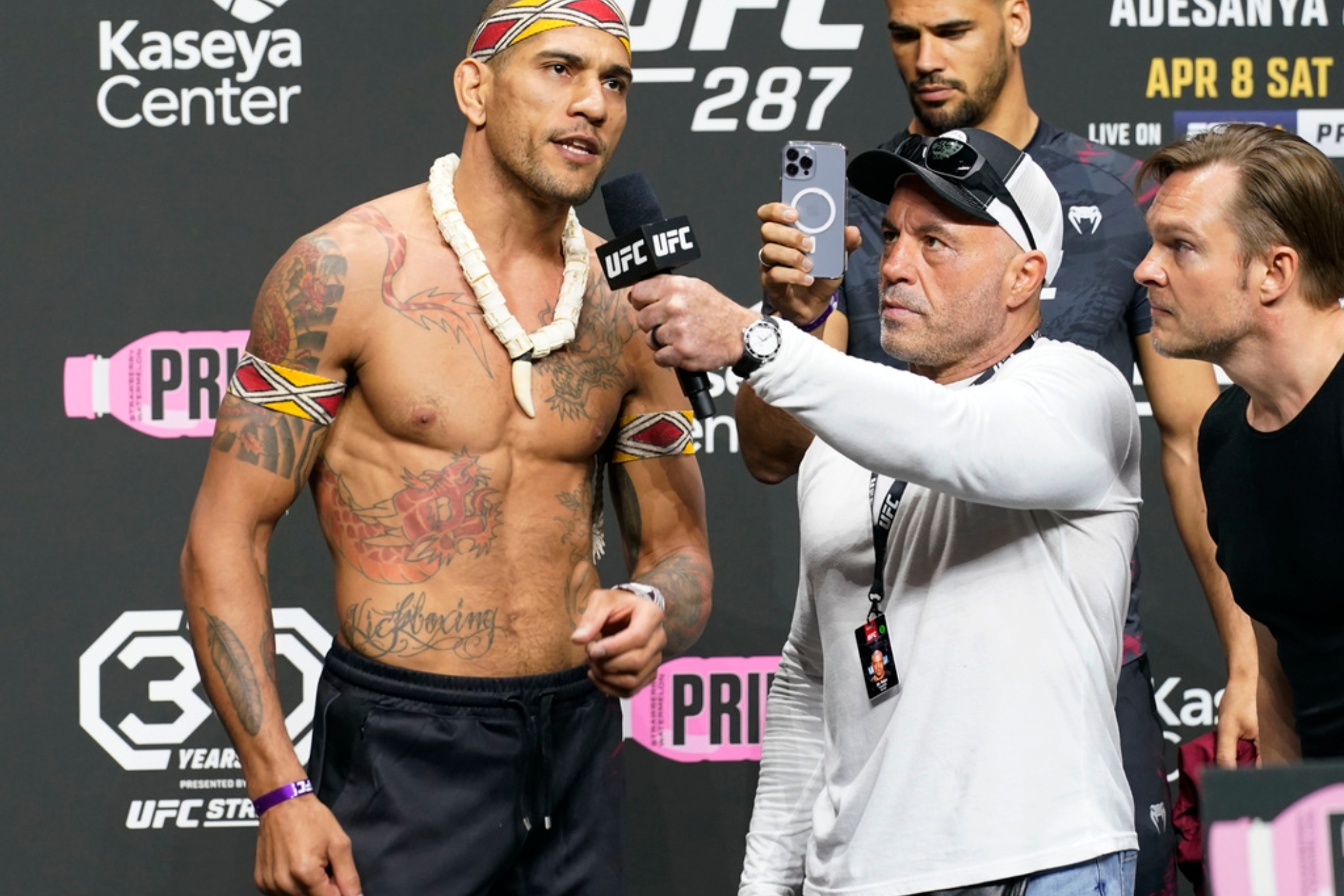 UFC commentator Joe Rogan, second from left, listens to Alex Pereira.