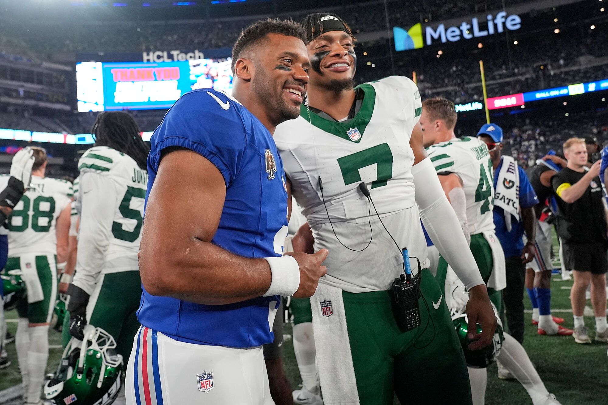 New York Giants quarterback Russell Wilson (3) and New York Jets quarterback Justin Fields (7) pose for a photo on the field after an NFL football game