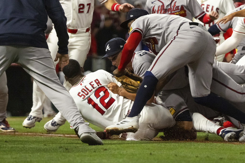 Jorge Soler (12) is tackled to the ground by Atlanta Braves players as a fight breaks out.
