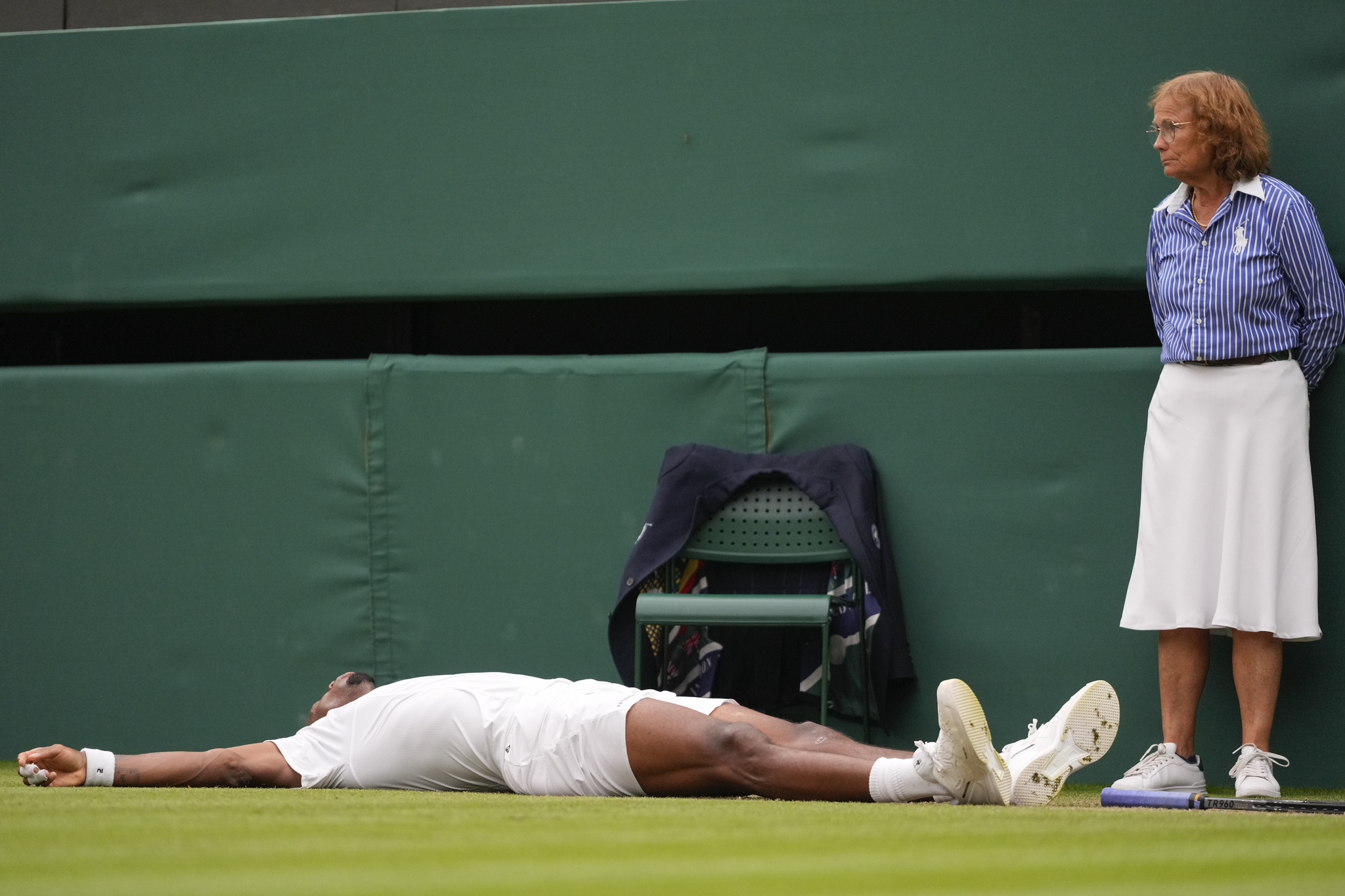 A line judge looks as Gael Monfils lies on the court after at Wimbledon.
