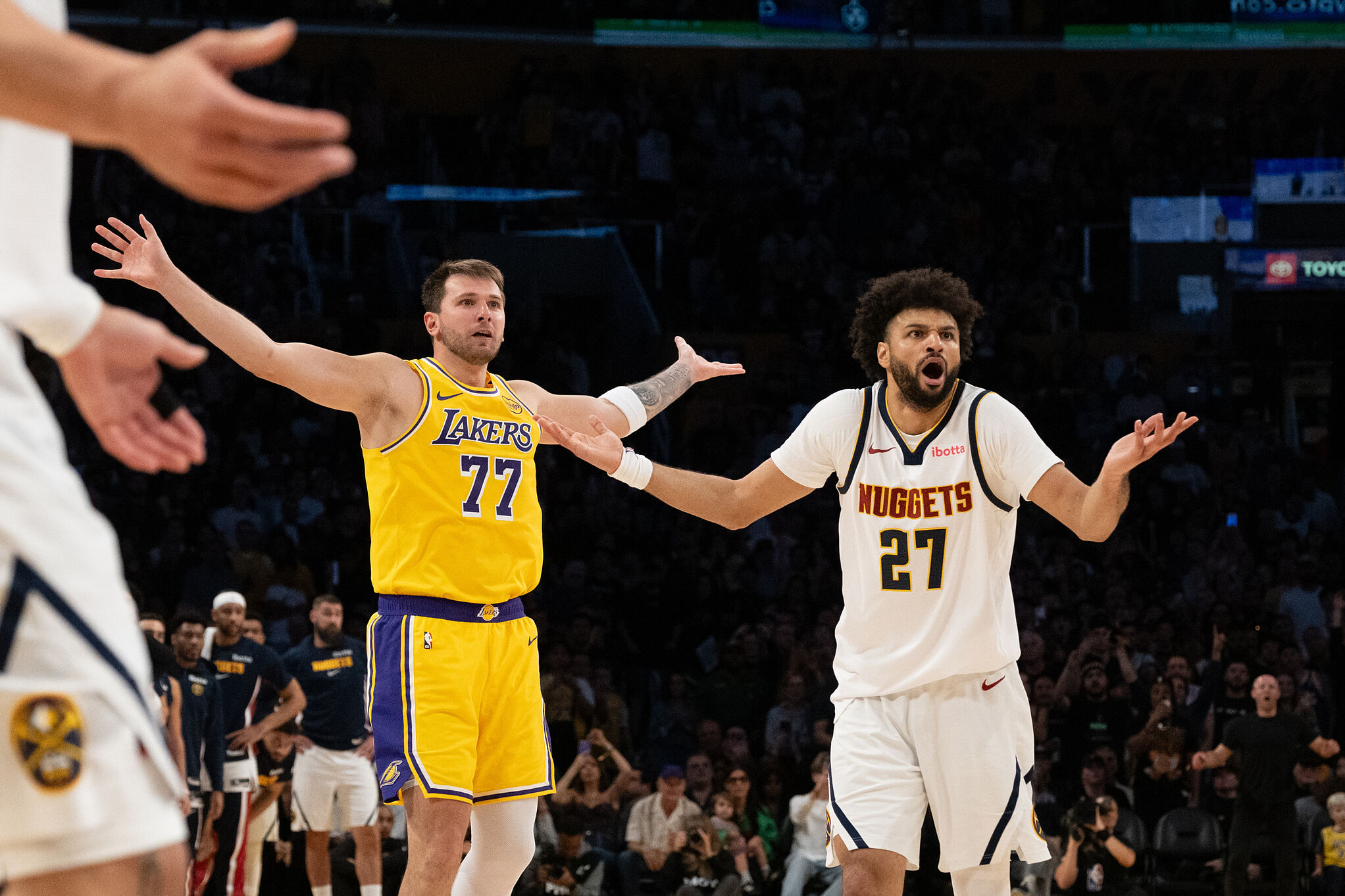 Los Angeles Lakers guard Luka Doncic, left, and Denver Nuggets guard Jamal Murray gesture during an NBA basketball game