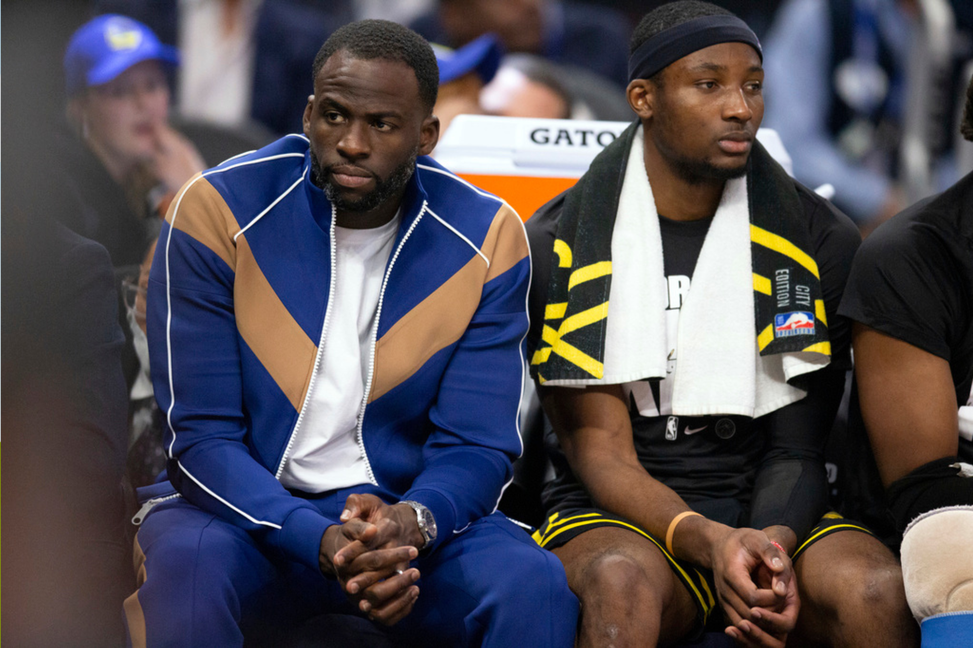 Golden State Warriors forwards Draymond Green, left, and Jonathan Kuminga watch the action from the bench during the first quarter of an NBA basketball game