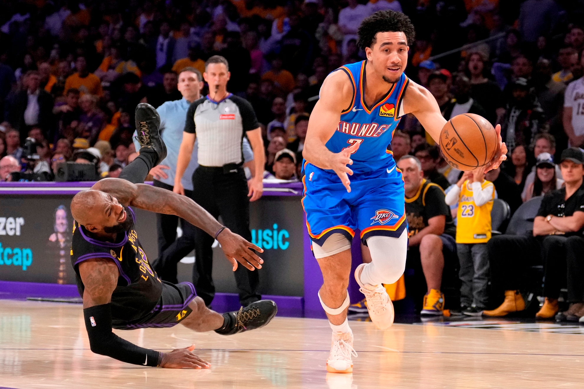 Oklahoma City Thunder guard Jared McCain, right, drives toward the basket as Los Angeles Lakers forward LeBron James falls during game 4 of the NBA playoffs