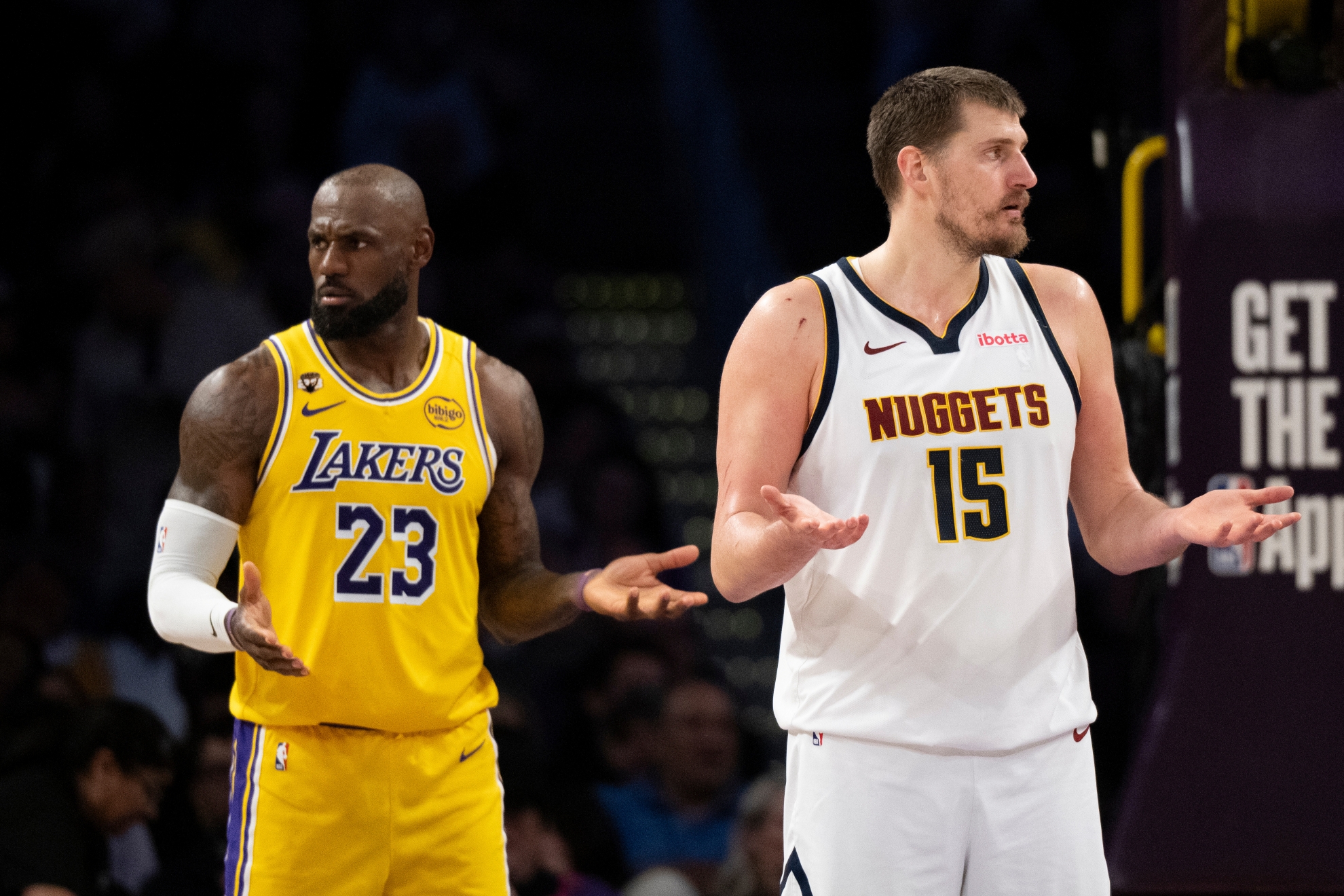 Los Angeles Lakers forward LeBron James, left, and Denver Nuggets center Nikola Jokic gesture during an NBA game in Los Angeles