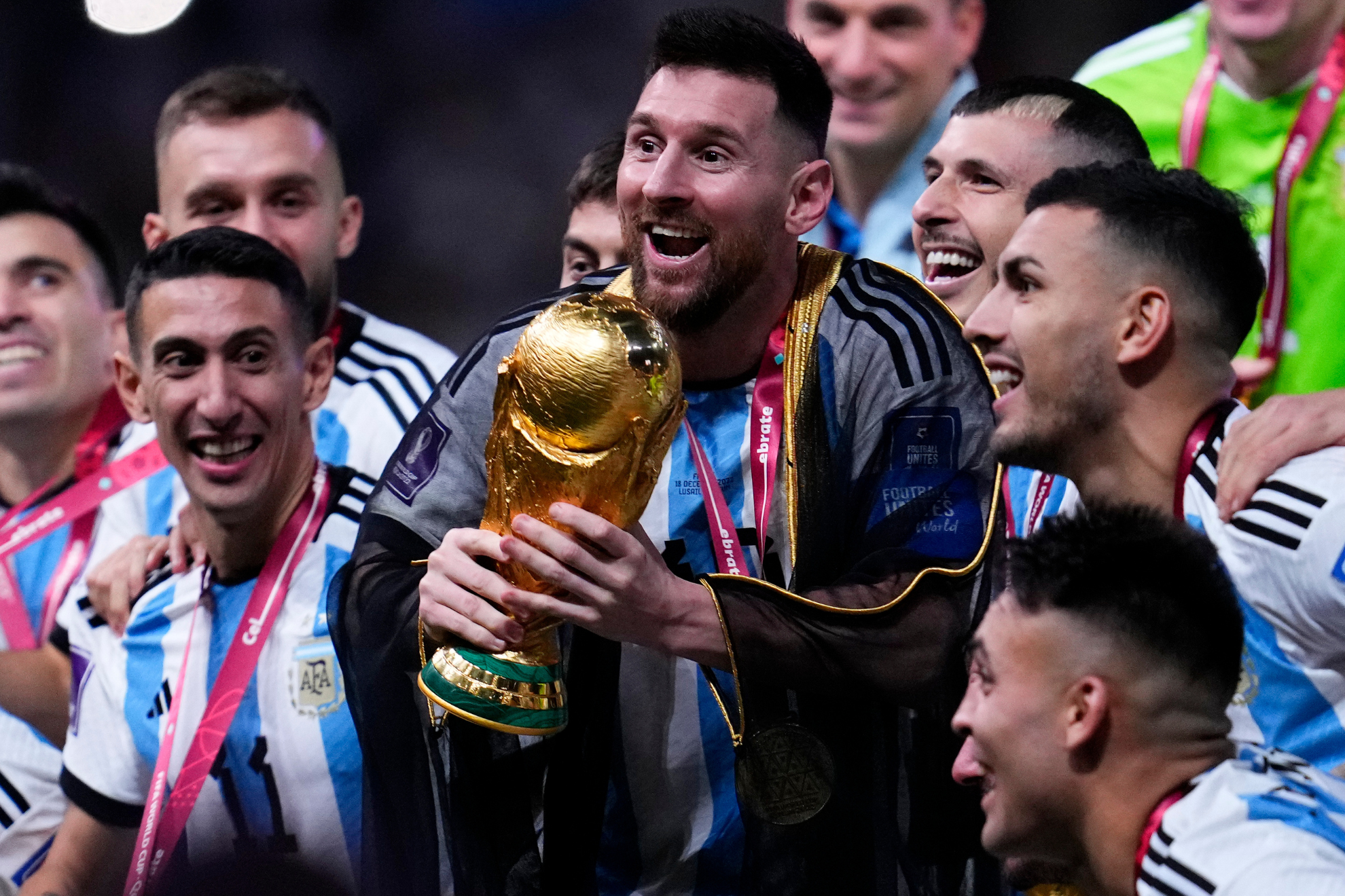 Argentina's Lionel Messi and teammates celebrate with the World Cup trophy after Argentina defeated France in the World Cup final soccer match at the Lusail Stadium in Lusail, Qatar, Sunday, Dec. 18, 2022.