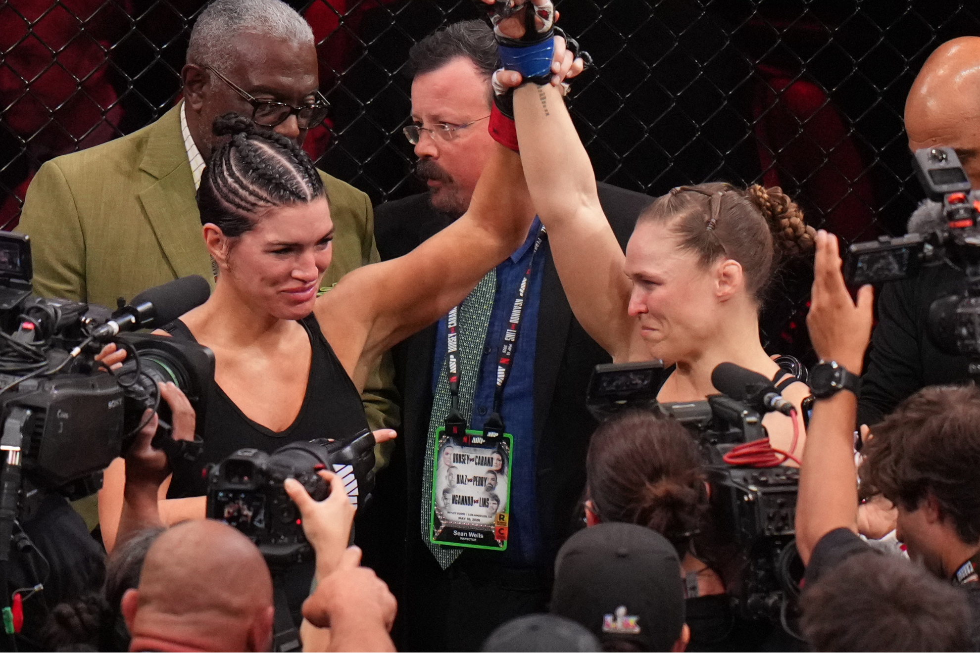 Gina Carano holds up Ronda Rousey's hand after their short-lived MMA bout.
