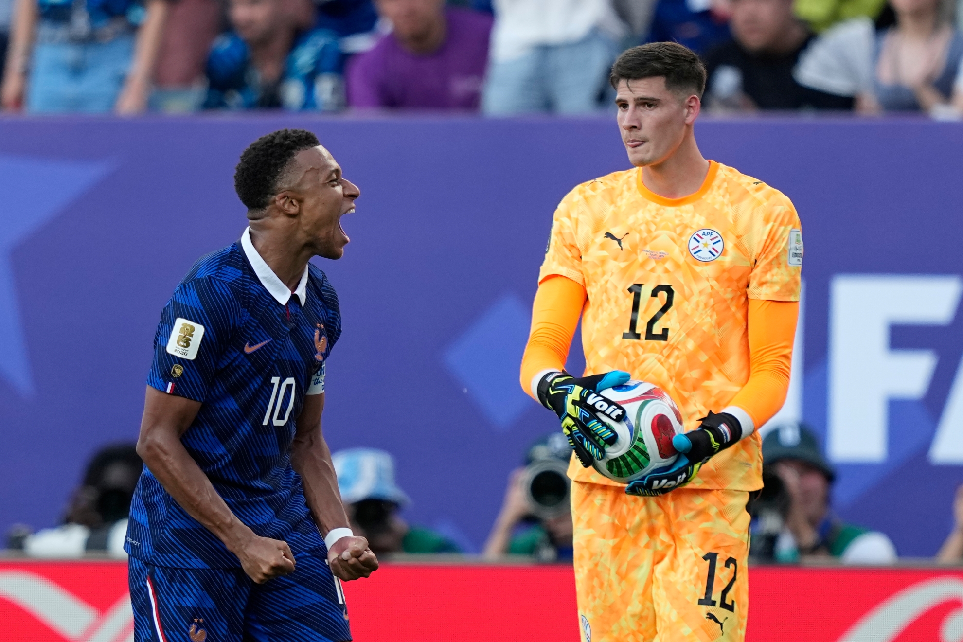 Kylian Mbappe celebrates France's victory as Paraguay goalkeeper Orlando Gill holds the ball after the final whistle of a World Cup round of 16