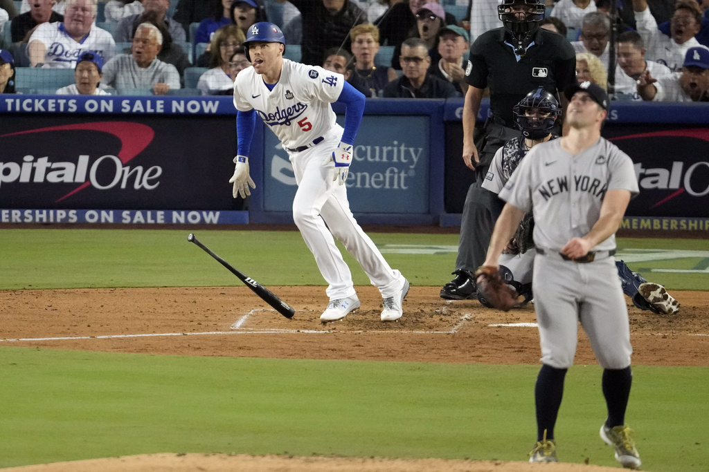 Los Angeles Dodgers' Freddie Freeman (5) watches his home run off New York Yankees starting pitcher Carlos Rodón, right, during the third inning in Game 2 of the baseball World Series, Saturday, Oct. 26, 2024, in Los Angeles. (AP Photo/Julio Cortez)