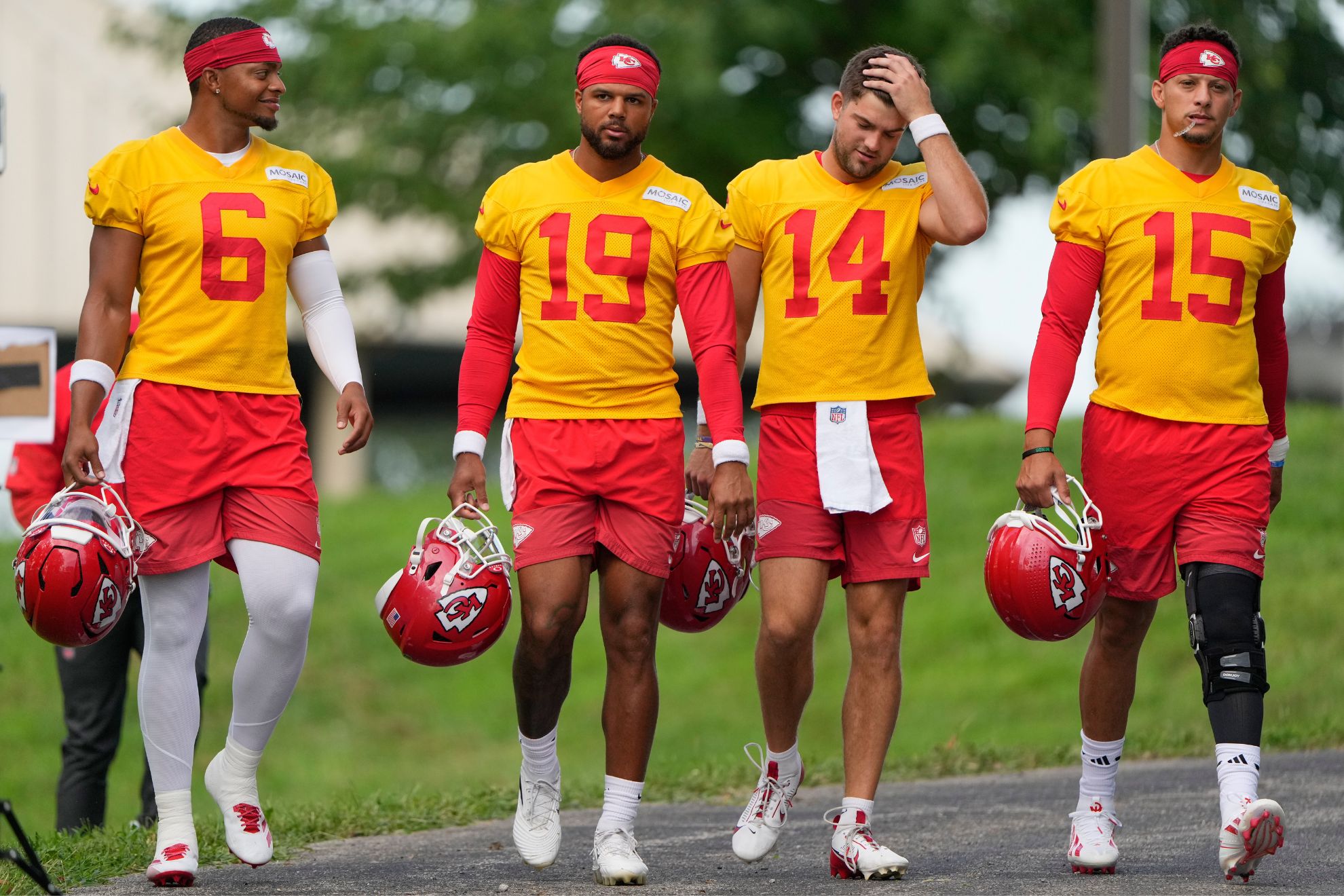 Kansas City Chiefs quarterbacks Justin Fields (6), Chris Oladokun (19), Garrett Nussmeier (14) and Patrick Mahomes (15) arrive at NFL football training camp