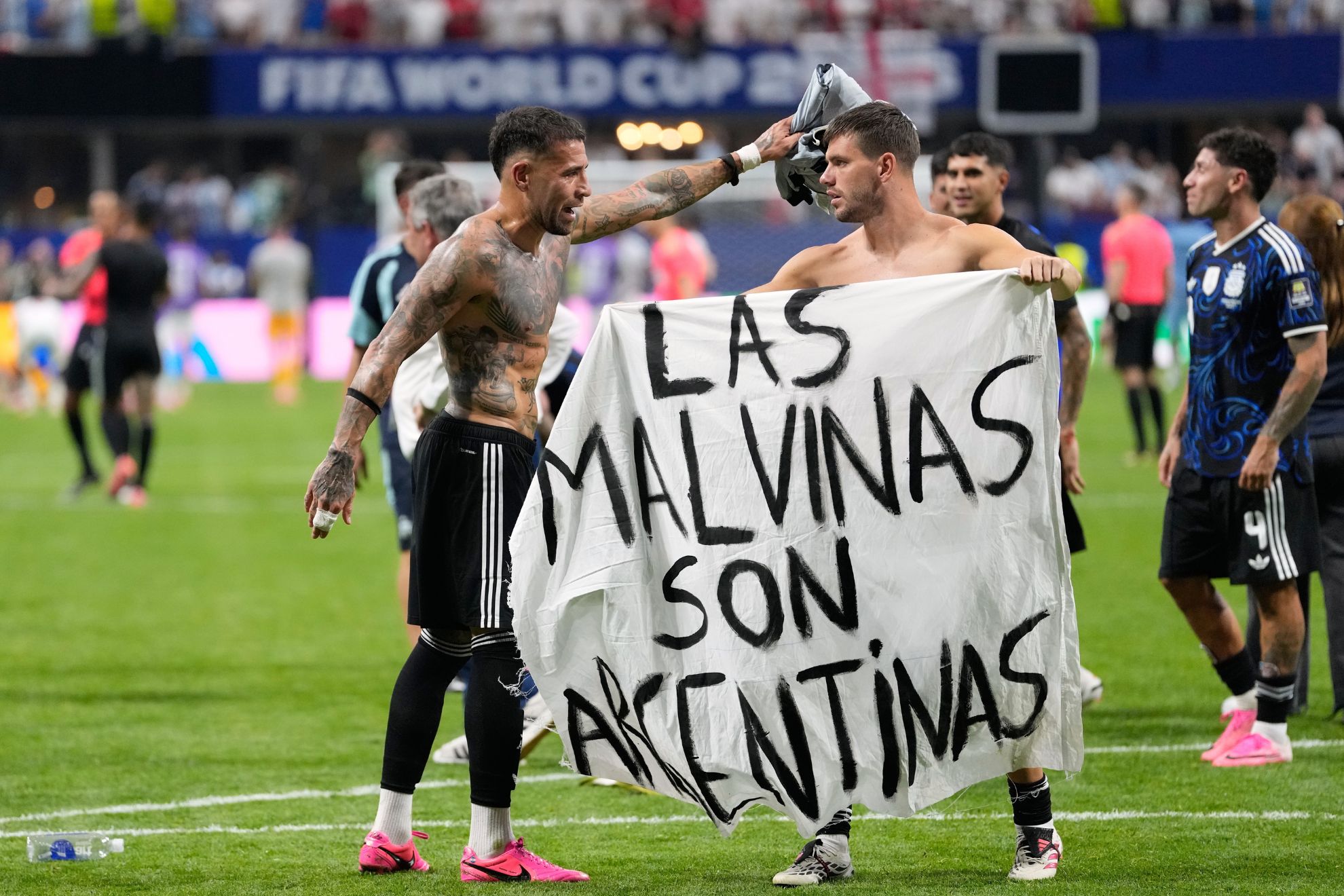 Argentina's Giovani Lo Celso holds a banner with the words 