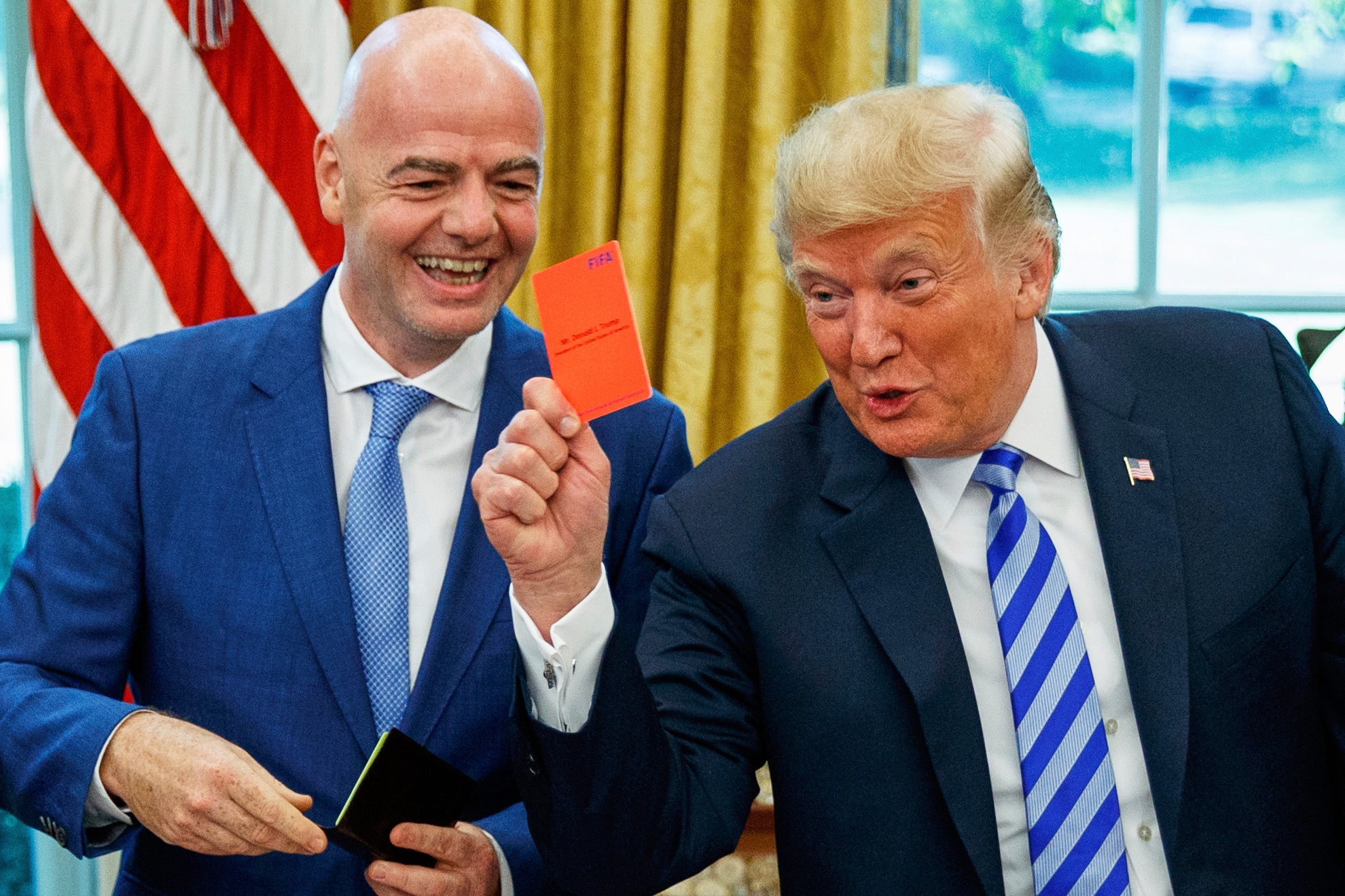 President Donald Trump holds up a red card during a meeting with FIFA president Gianni Infantino. LAPRESSE