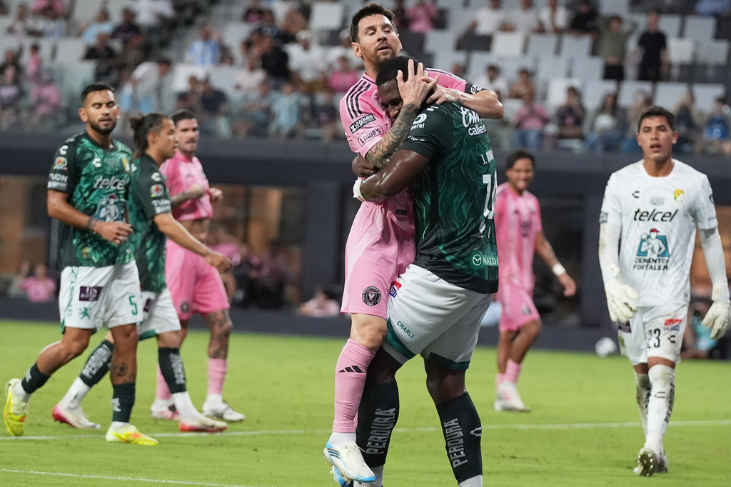 Inter Miami forward Lionel Messi, center, collided with Club León defender Jhohan Romaña (14) during the second half of a Leagues Cup soccer match, Wednesday, Aug. 12, 2026, in Miami. (AP Photo/Lynne Sladky)
