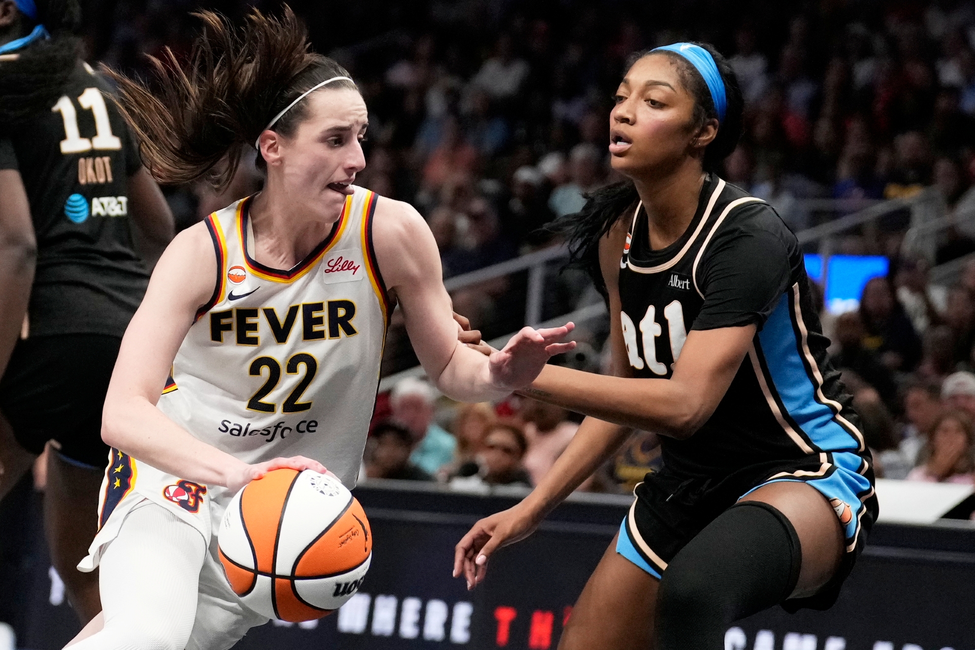 Indiana Fever's Caitlin Clark (22) dribbles the ball against Atlanta Dream forward Angel Reese (5)