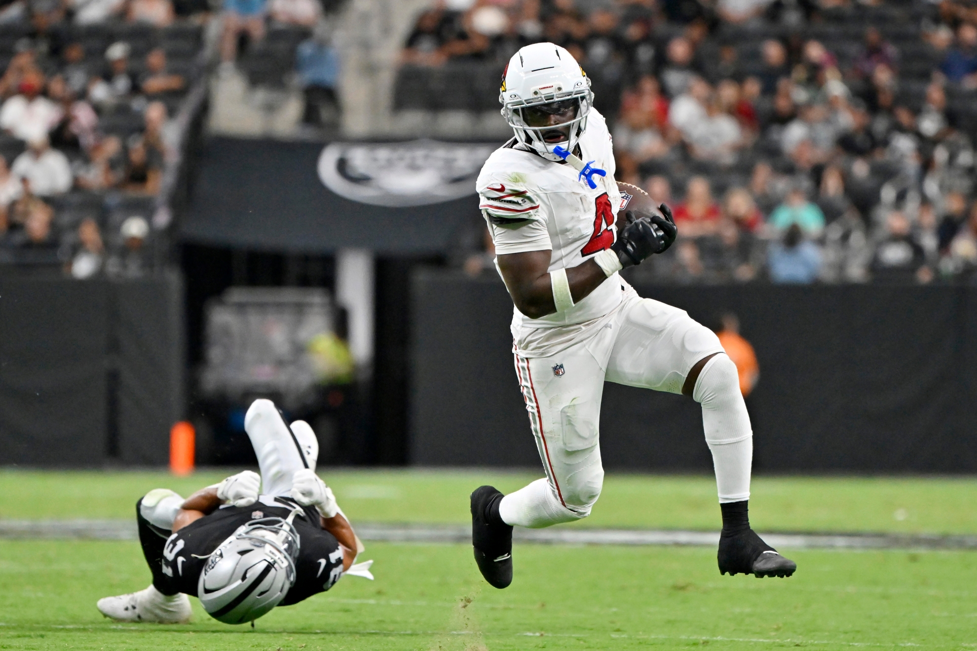 Arizona Cardinals running back Jeremiyah Love, right, runs past Las Vegas Raiders safety Treydan Stukes (31)