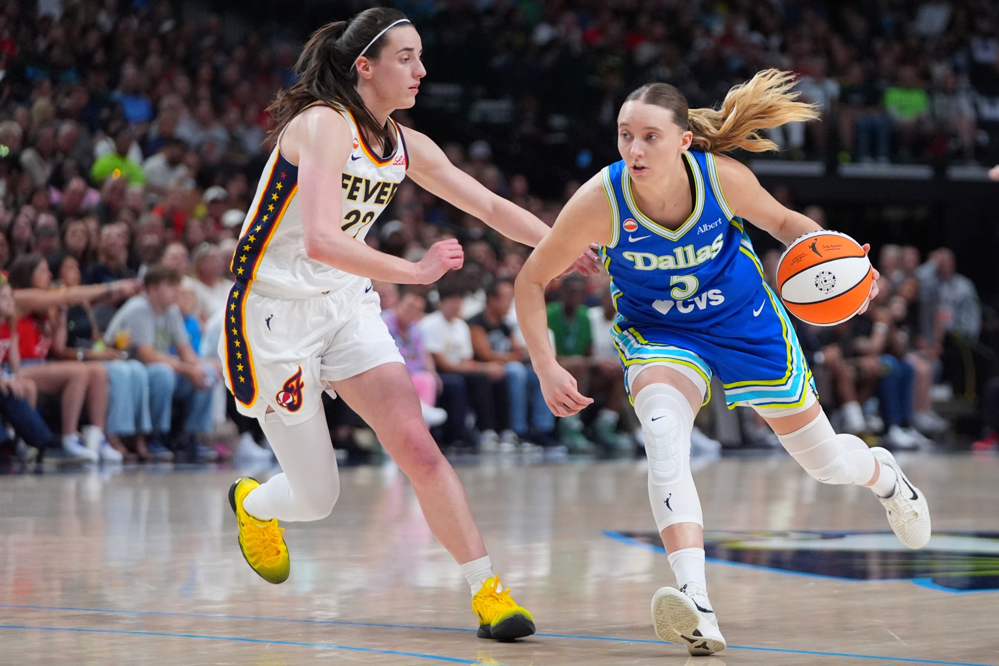 Dallas Wings guard Paige Bueckers, right, drives against Indiana Fever guard Caitlin Clark during a WNBA basketball game in Dallas