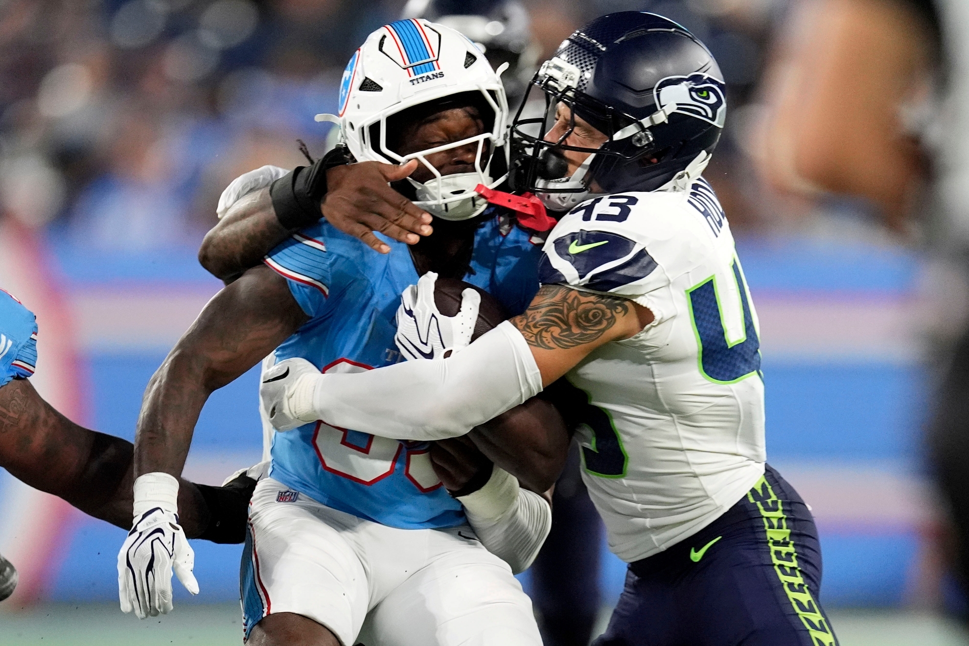 Tennessee Titans running back Michael Carter is tackled by Seattle Seahawks safety Maxen Hook during an NFL preseason game