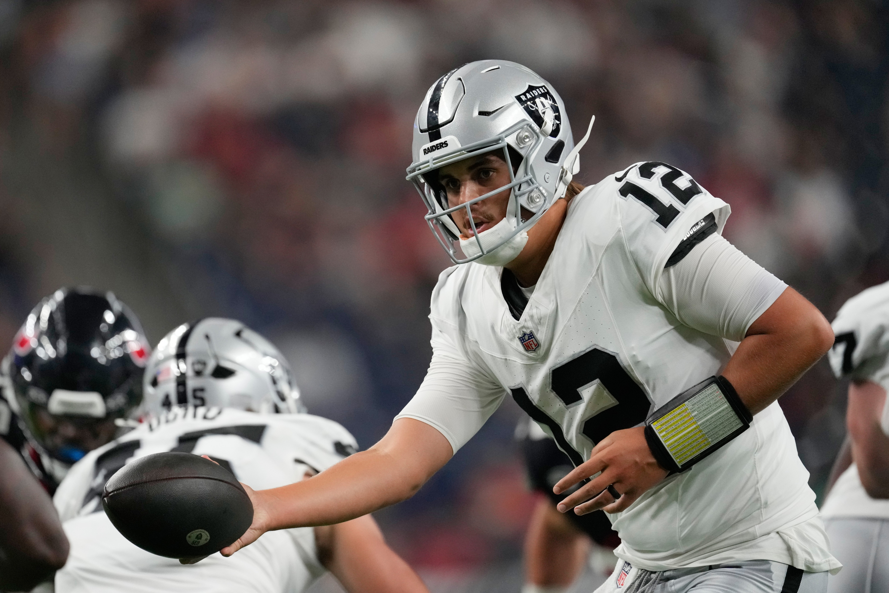 Las Vegas Raiders quarterback Aidan O'Connell (12) hands off during the second half of an NFL preseason football game against the Houston Texans, Thursday, Aug. 20, 2026, in Houston. (AP Photo/Ashley Landis) Ashley Landis
