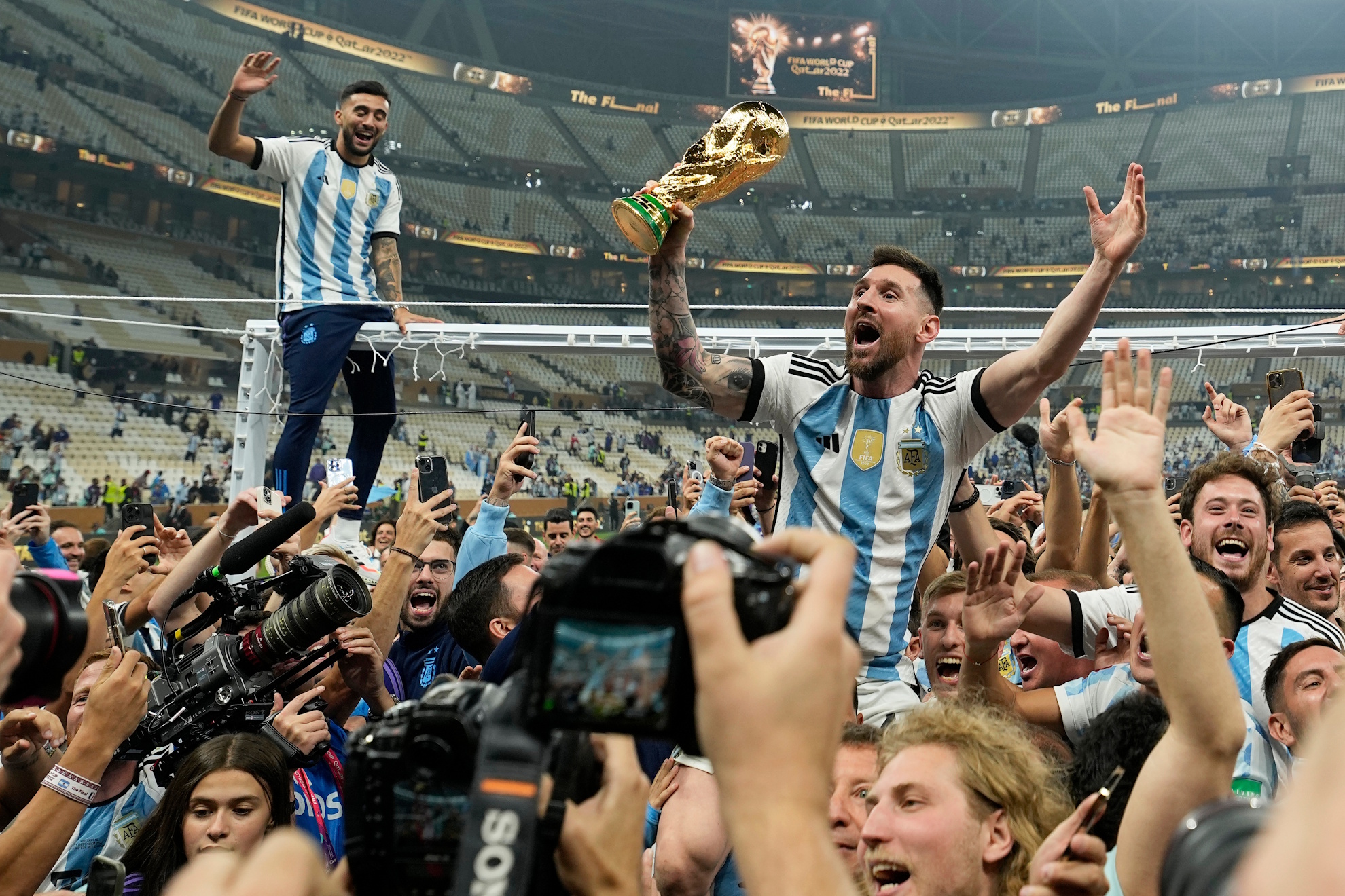 Lionel Messi celebrates with the trophy in front of fans after winning the World Cup in Qatar. LAPRESSE