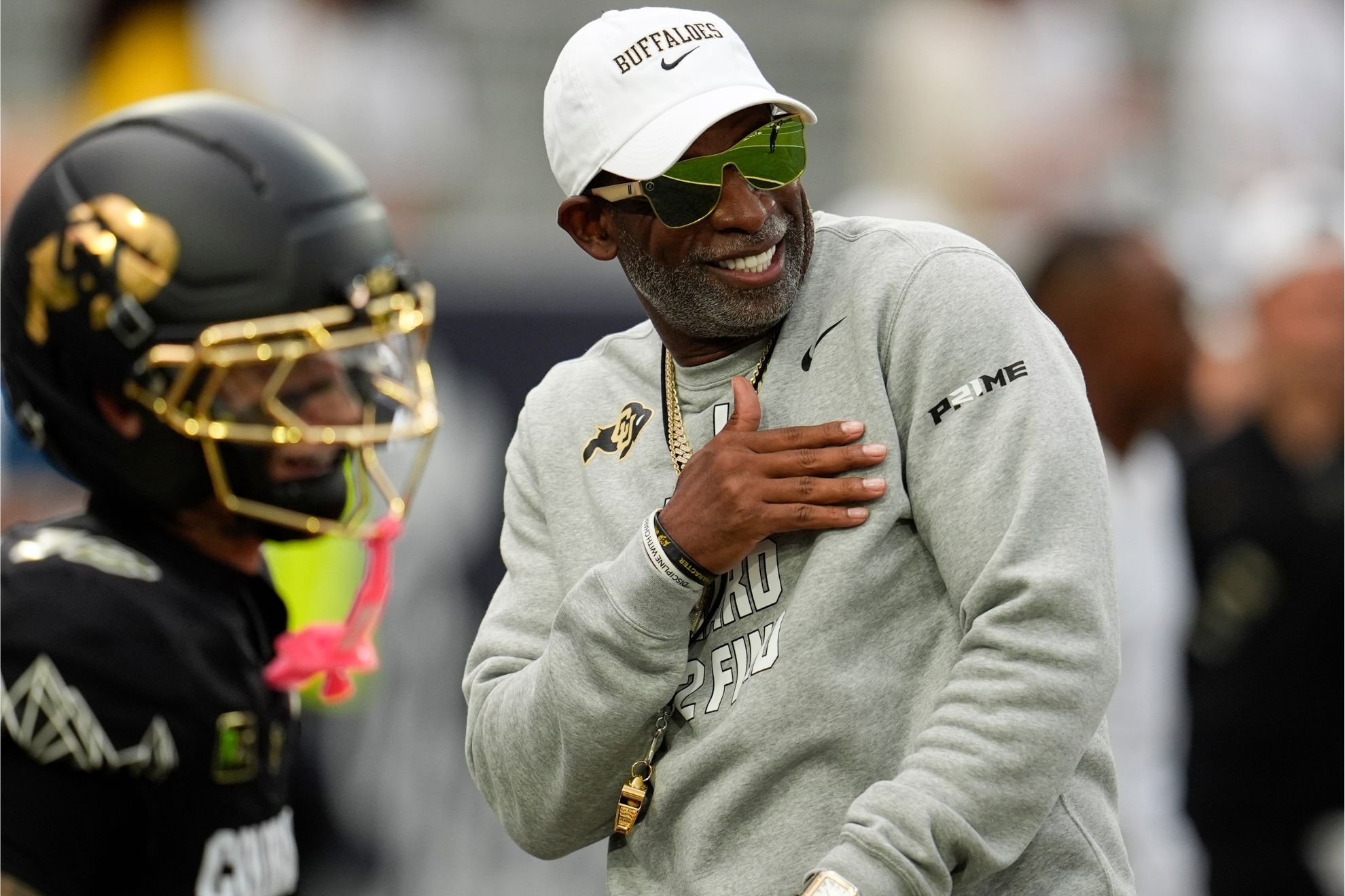 Deion Sanders walks on the field before an NCAA college football game between Georgia Tech and Colorado