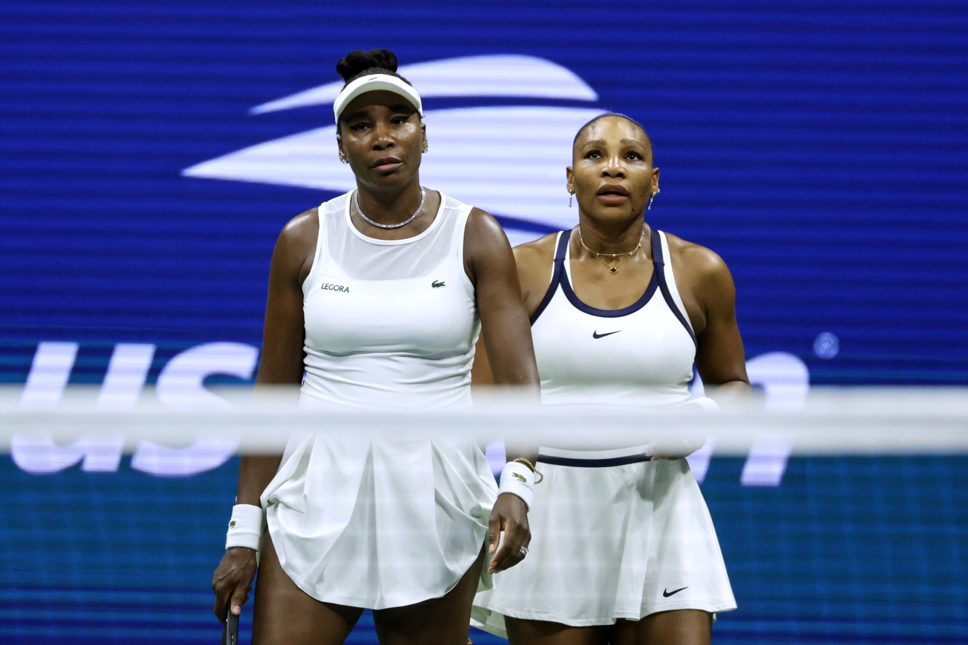 Venus Williams, left, and Serena Williams, of the United States, look on as they play against Hao-Ching Chan, of Taiwan, and Maya Joint, of Australia