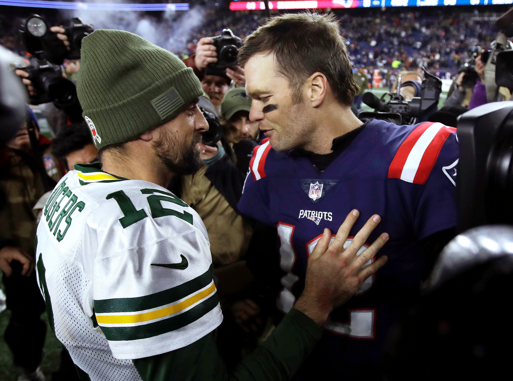 Green Bay Packers quarterback Aaron Rodgers, left, and New England Patriots quarterback Tom Brady speak at midfield after an NFL football game