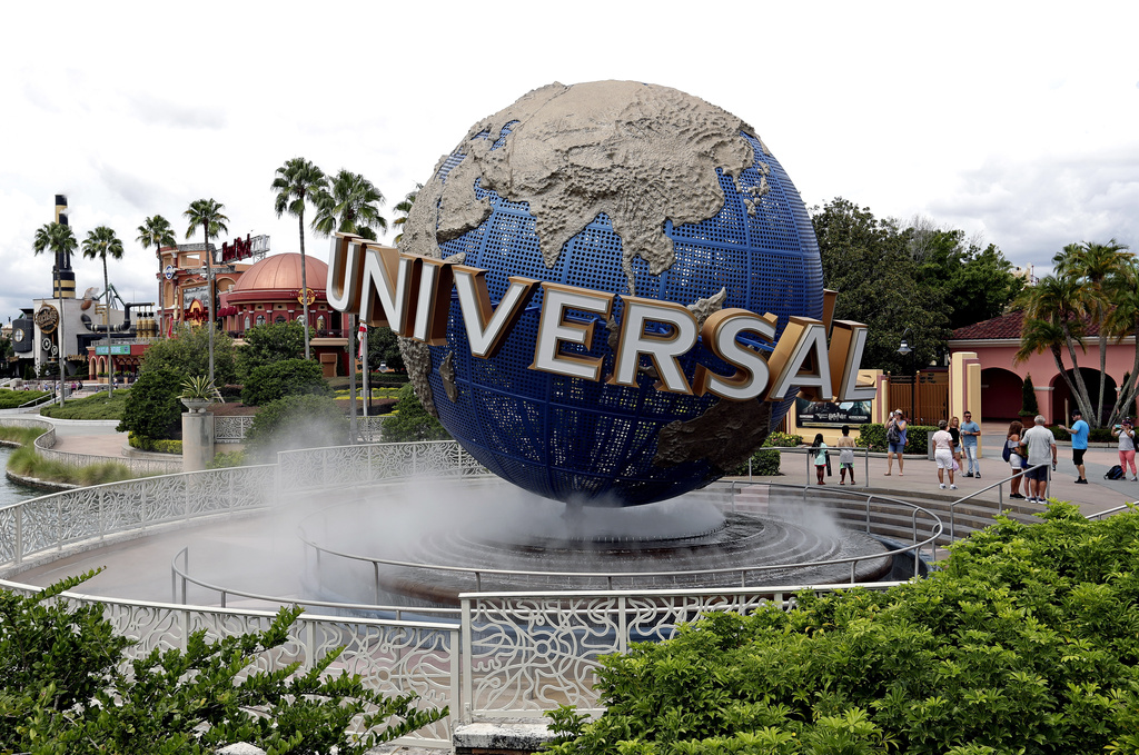 FILE - Guests cool off under a water mist by the globe at Universal Studios City Walk at Universal Studios Florida in Orlando, Fla., Aug. 5, 2019. (AP Photo/John Raoux, File) LAPRESSE