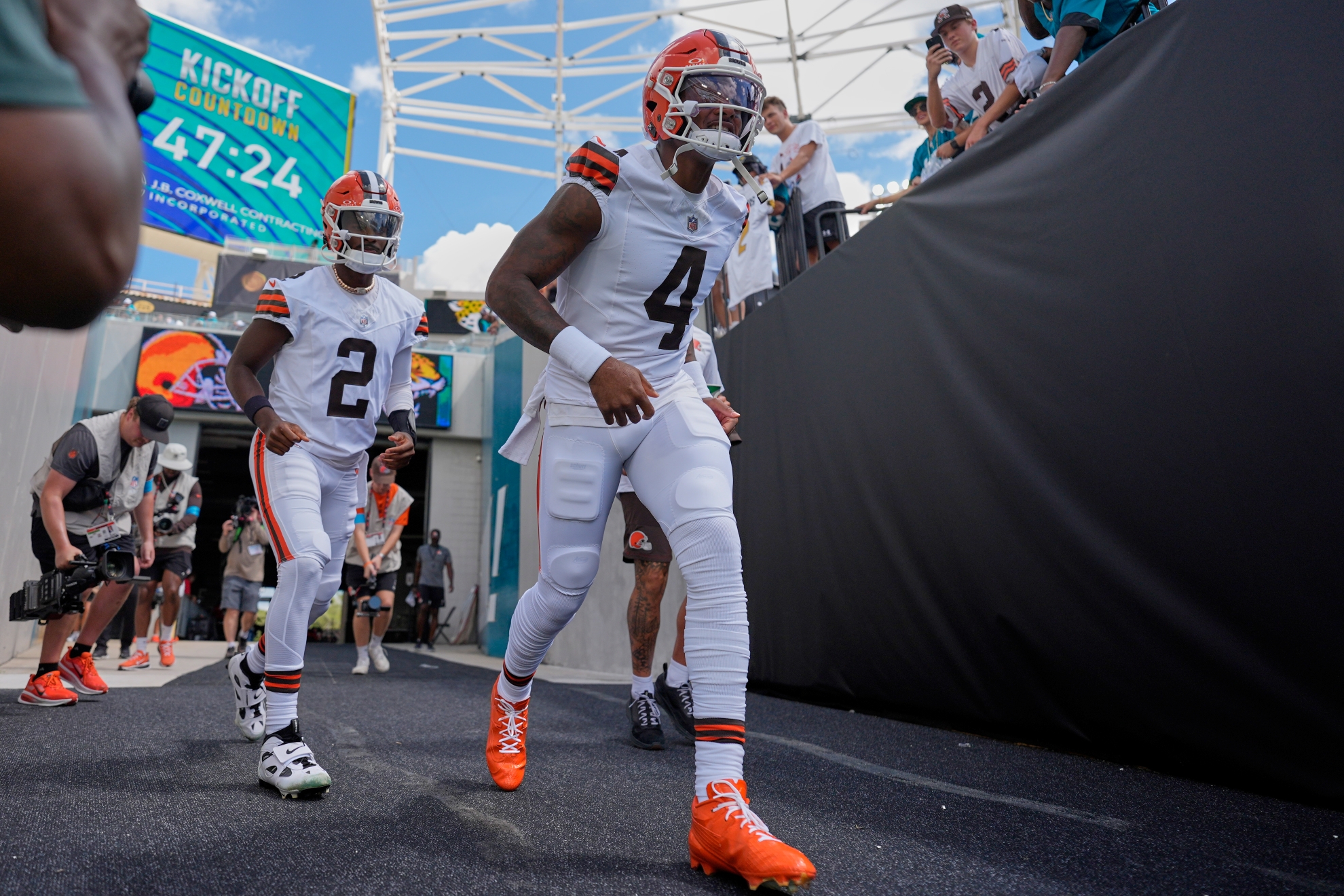 Cleveland Browns quarterback Deshaun Watson (4) and quarterback Shedeur Sanders (2) run onto the field before an NFL game against the Jacksonville Jaguars