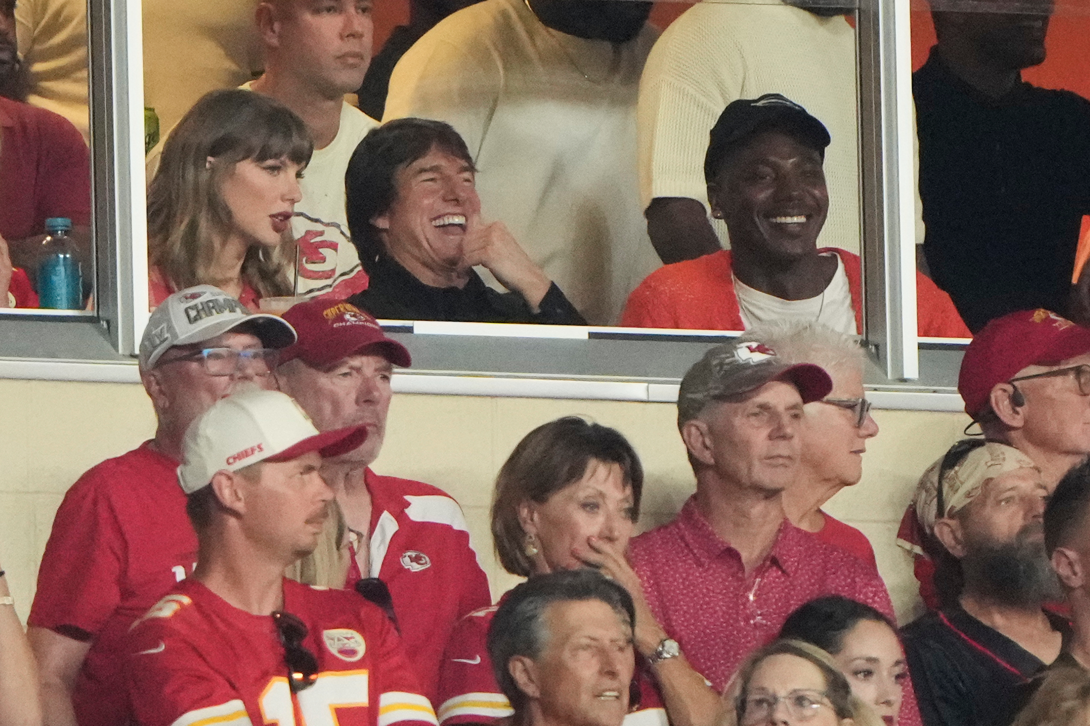 Taylor Swift, left, sits with Tom Cruise, center, while watching the first half of an NFL football game between the Kansas City Chiefs and the Denver Broncos, LAPRESSE