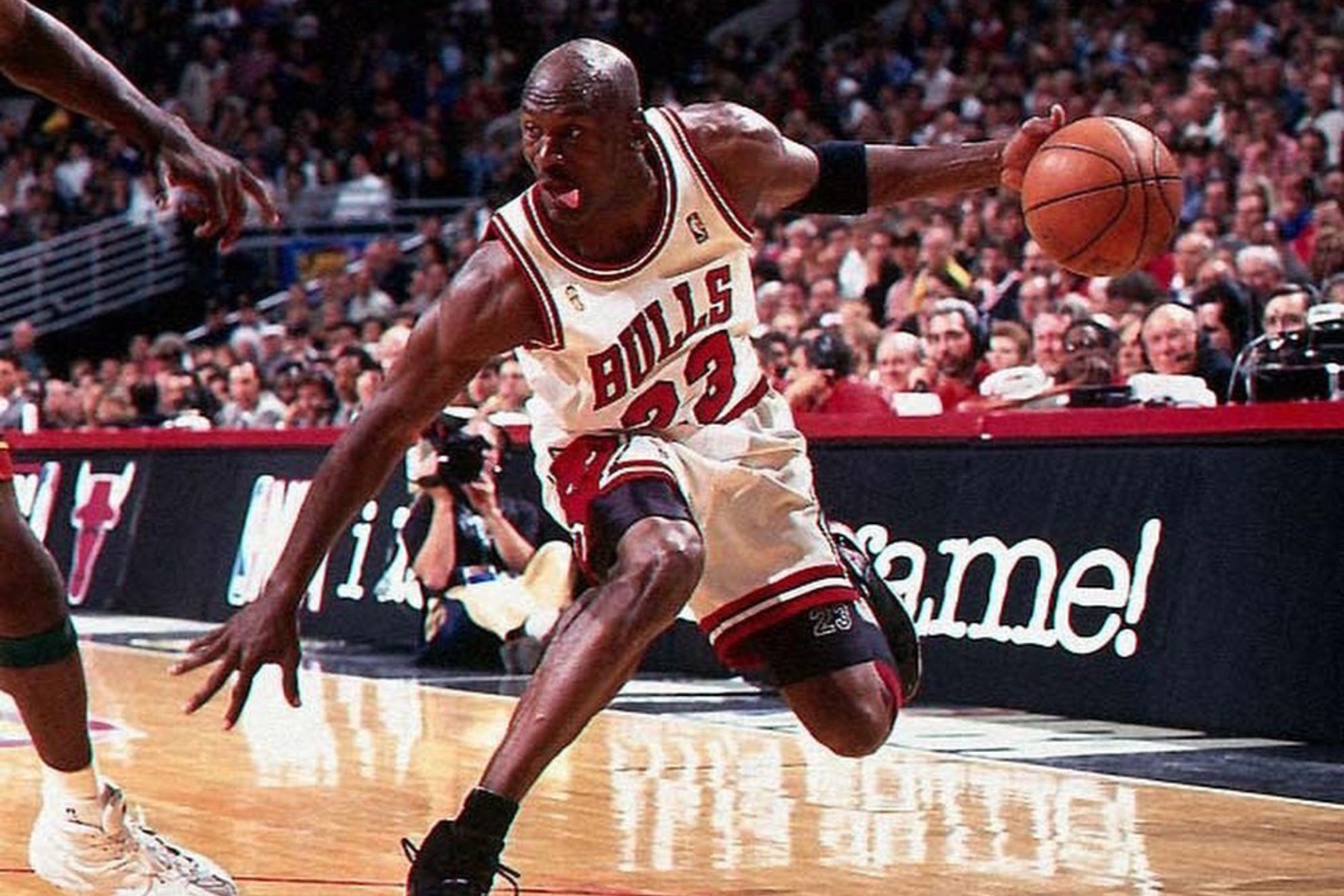 Michael Jordan in a spectacular play with his characteristic gesture