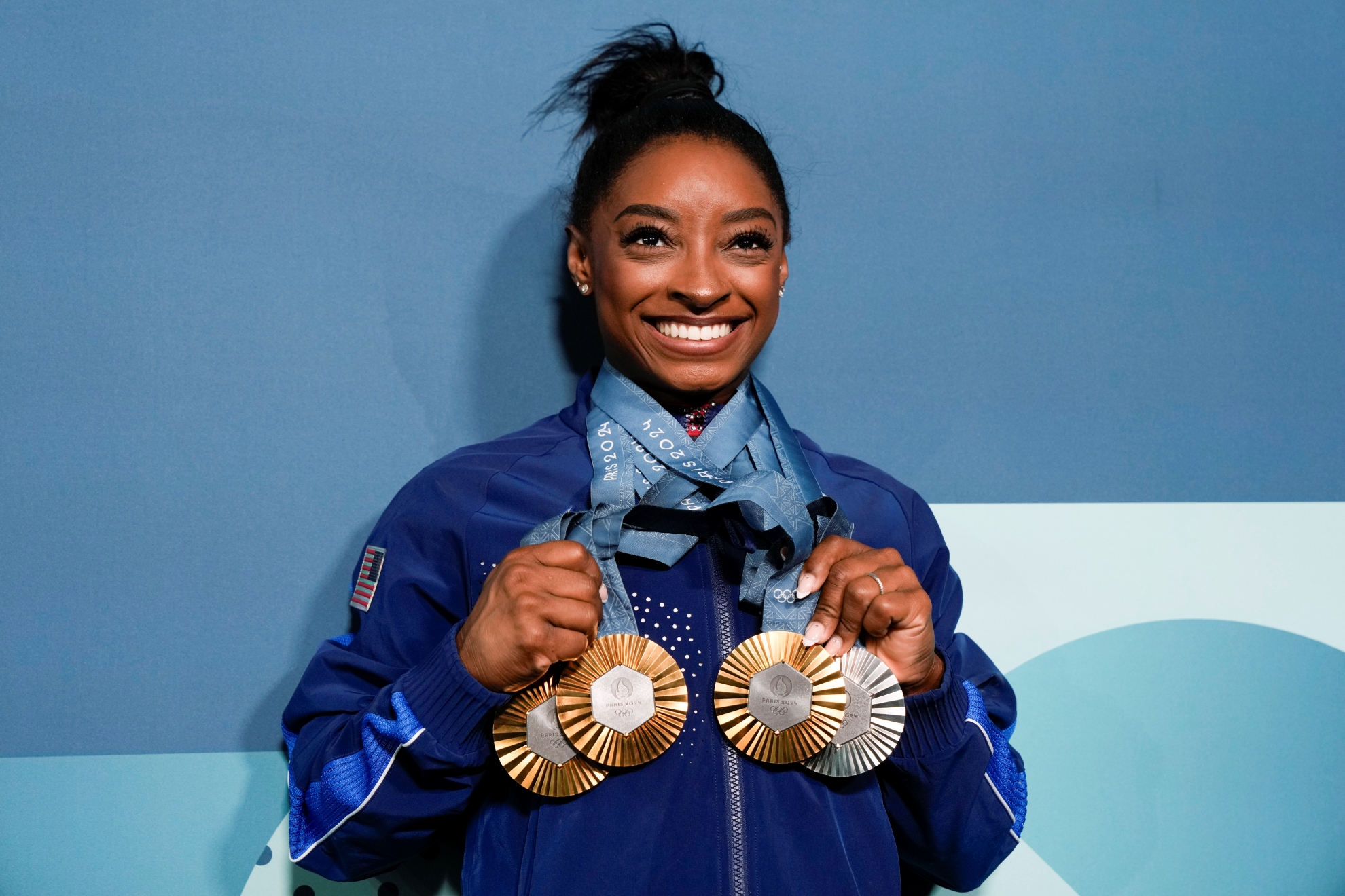 Simone Biles holds up her Women's Artistic Gymnastics medals won at the 2024 Summer Olympics LAPRESSE