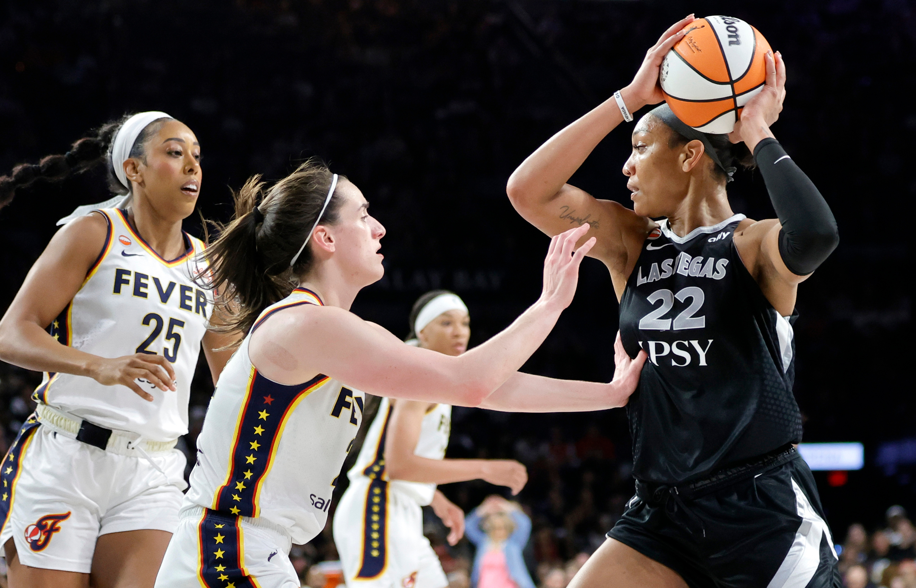 Indiana Fever forward Monique Billings (25) and guard Caitlin Clark, center, put pressure on Las Vegas Aces center A'ja Wilson (22) during the second half in Game 1 of a WNBA basketball first-round playoff series Sunday, Sept. 27, 2026, in Las Vegas. (AP Photo/Steve Marcus) Steve Marcus