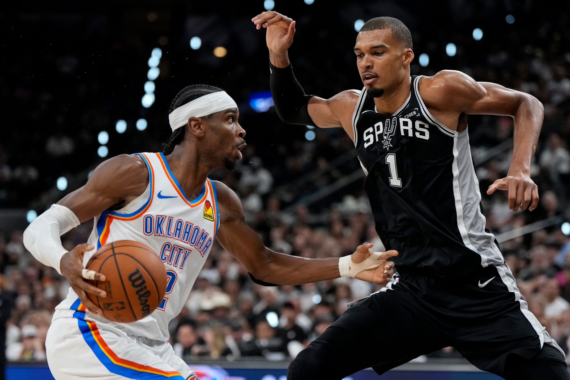 Oklahoma City Thunder guard Shai Gilgeous-Alexander (2) drives against San Antonio Spurs forward Victor Wembanyama (1)