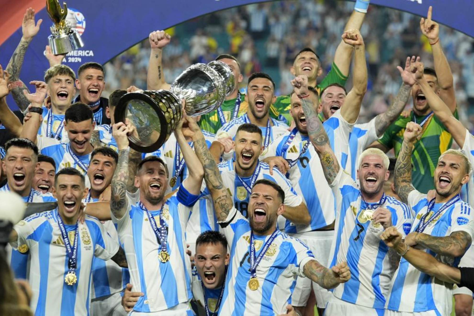 Lionel Messi holds the trophy while celebrating with his teammates after defeating Colombia in the 2024 Copa América final Rebecca Blackwell