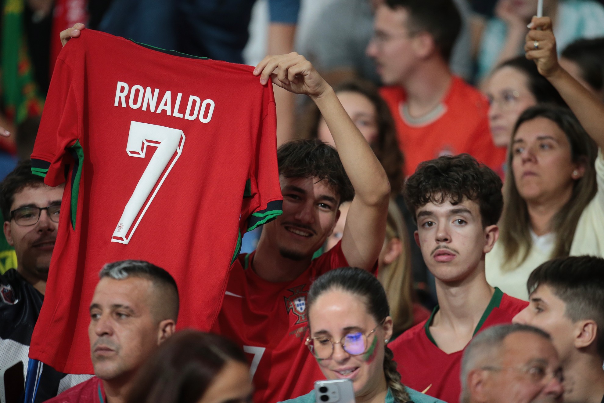 A fan of Potugal holds up Cristiano Ronaldo's jersey /