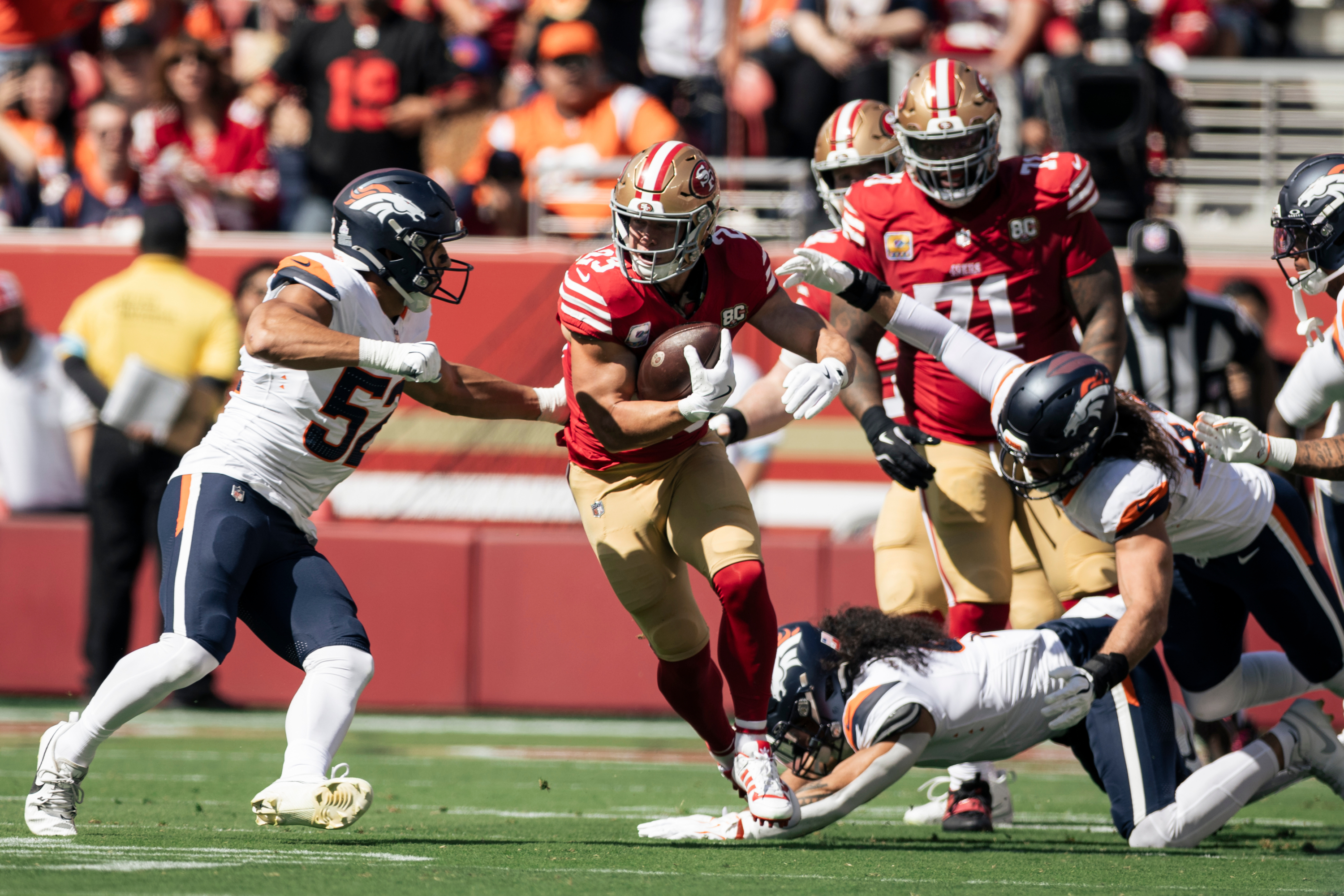 San Francisco 49ers running back Christian McCaffrey (23) rushes upfield as Denver Broncos outside linebacker Nik Bonitto (15) defends during the first half of a NFL football game at Levi's Stadium in Santa Clara, Calif., Sunday, Oct. 4, 2026. (Stephen Lam/San Francisco Chronicle via AP) Stephen Lam
