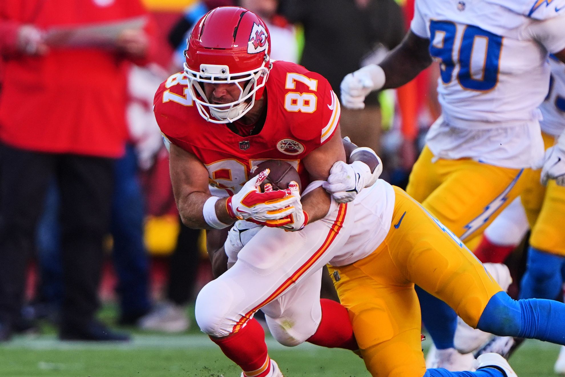 Kansas City Chiefs tight end Travis Kelce (87) catches a pass and is tackled by Los Angeles Chargers linebacker Daiyan Henley