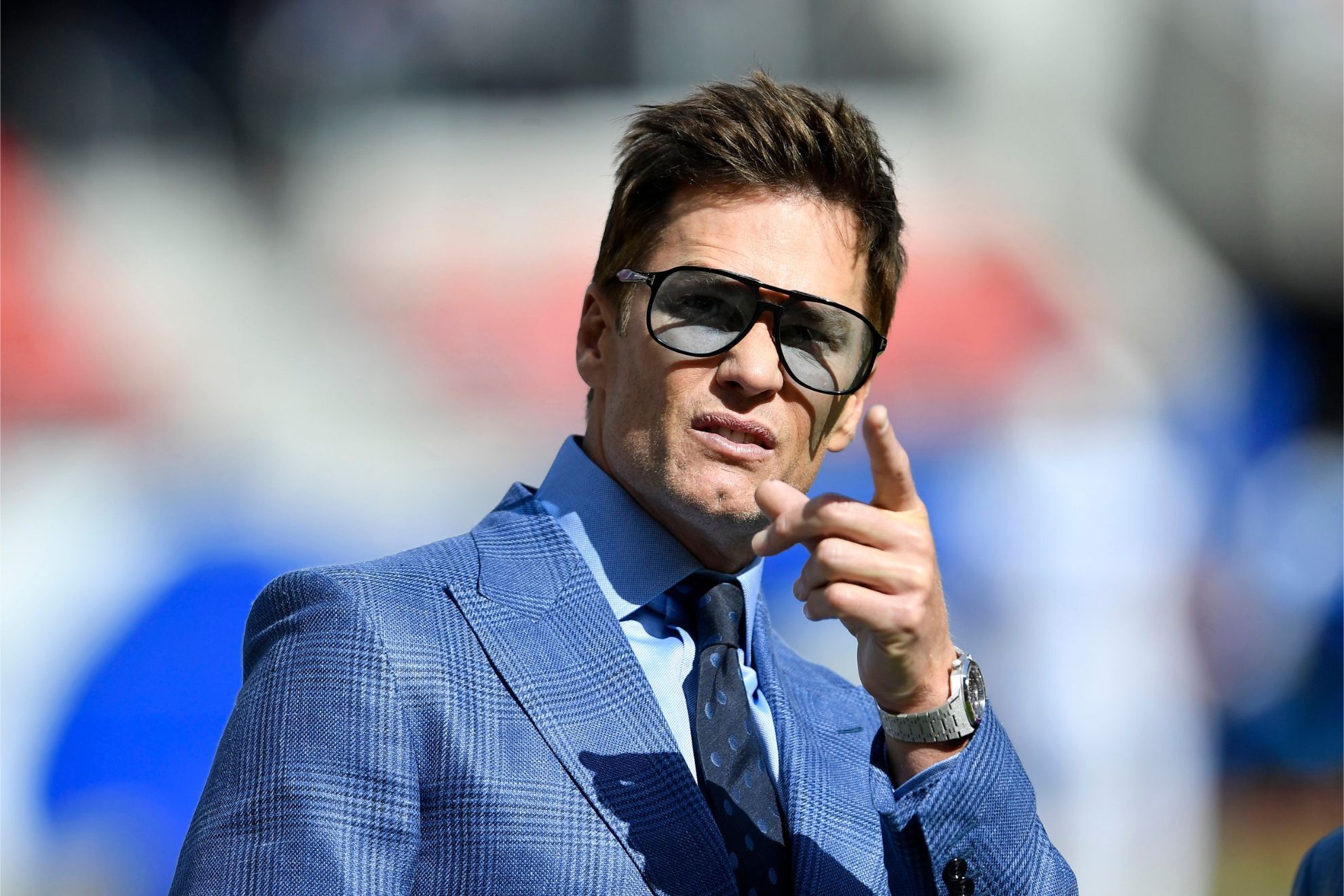 Tom Brady stands on the field before an NFL football game