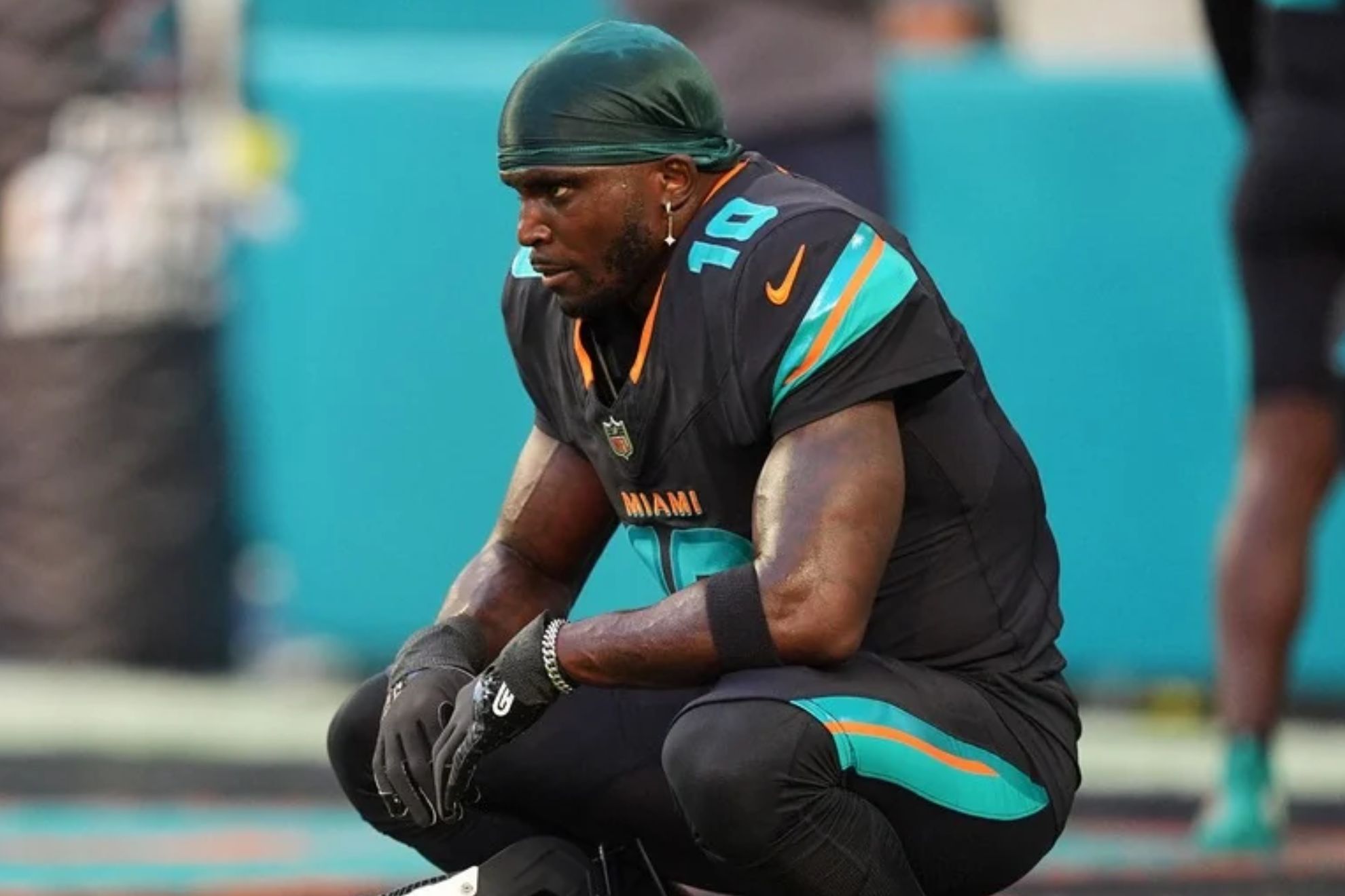 Miami Dolphins wide receiver Tyreek Hill sits in the end zone before an NFL football game