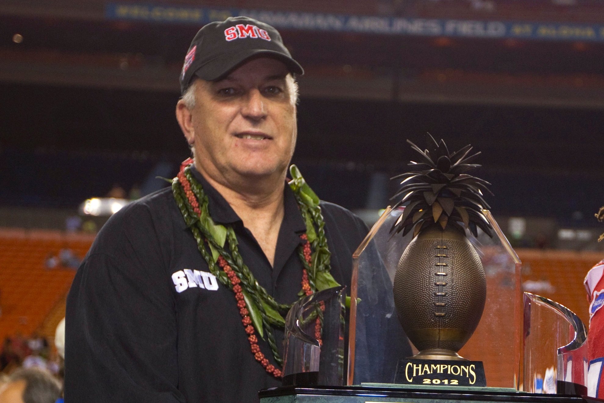 June Jones poses for a photo with the trophy for the Hawaii Bowl after SMU defeated Fresno State 43-10 in 2012. LAPRESSE